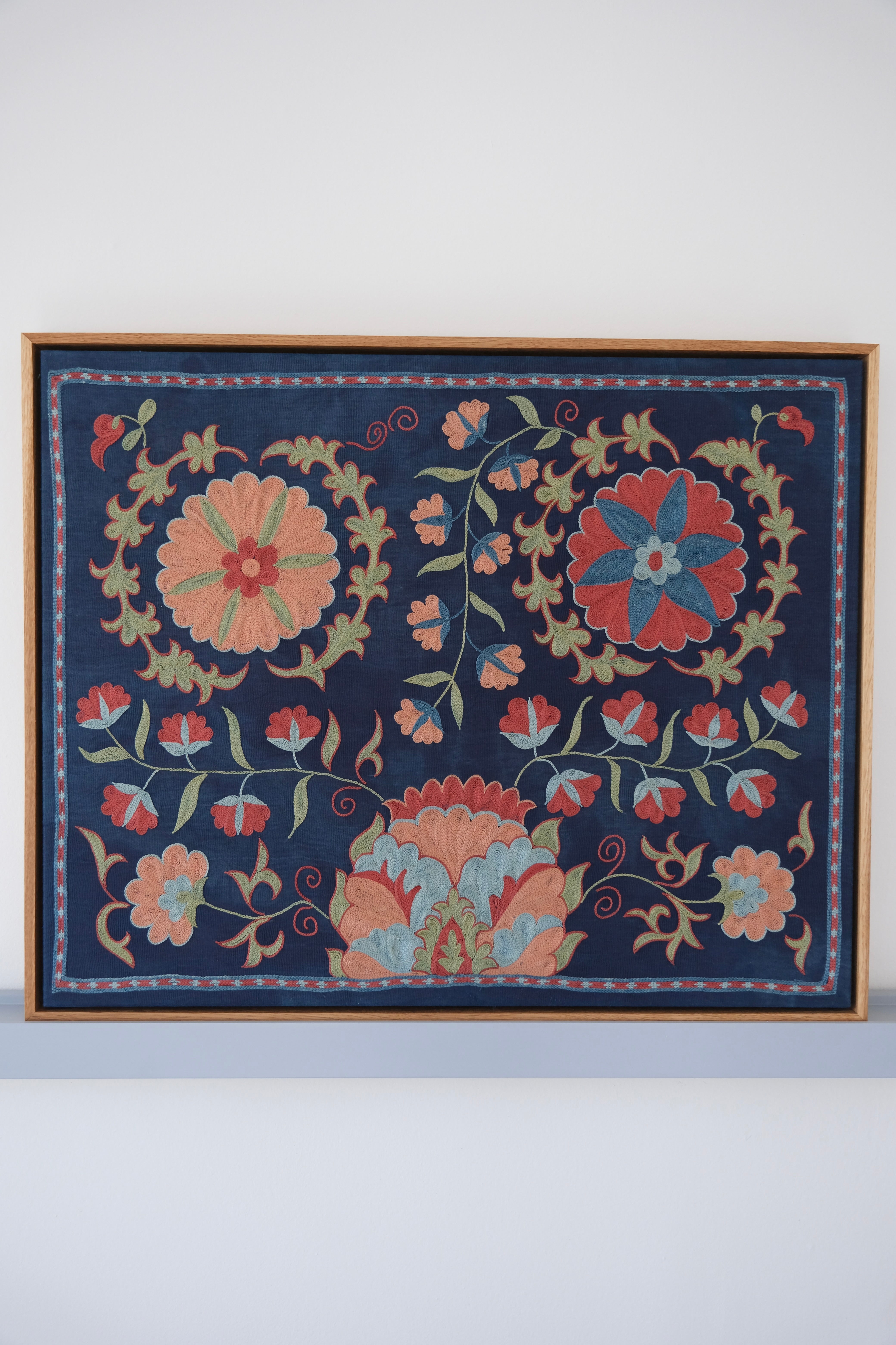 Framed suzani, embroidered textile art, wooden frame, navy blue with floral motifs