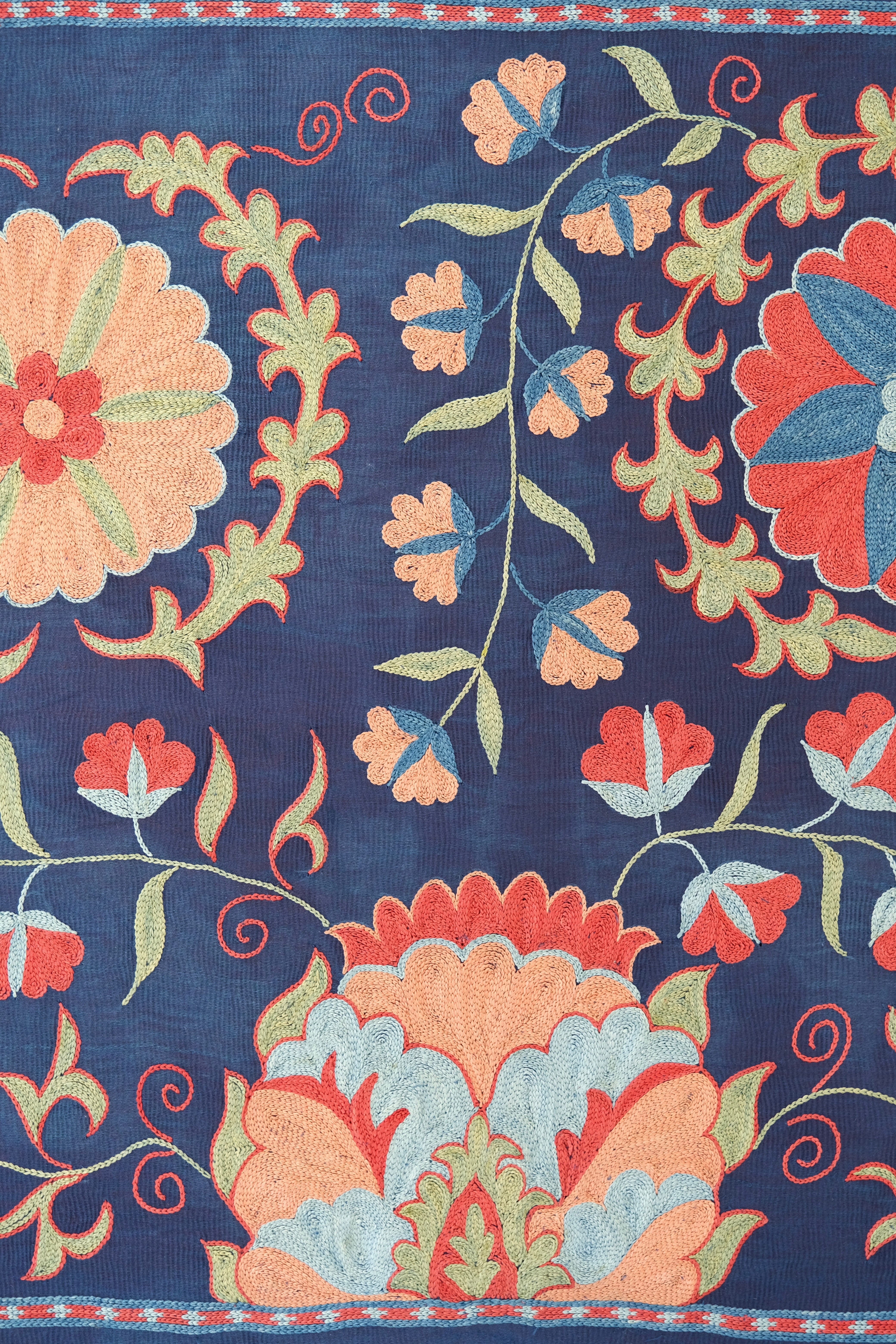 Framed suzani, embroidered textile art, wooden frame, navy blue with floral motifs, close-up