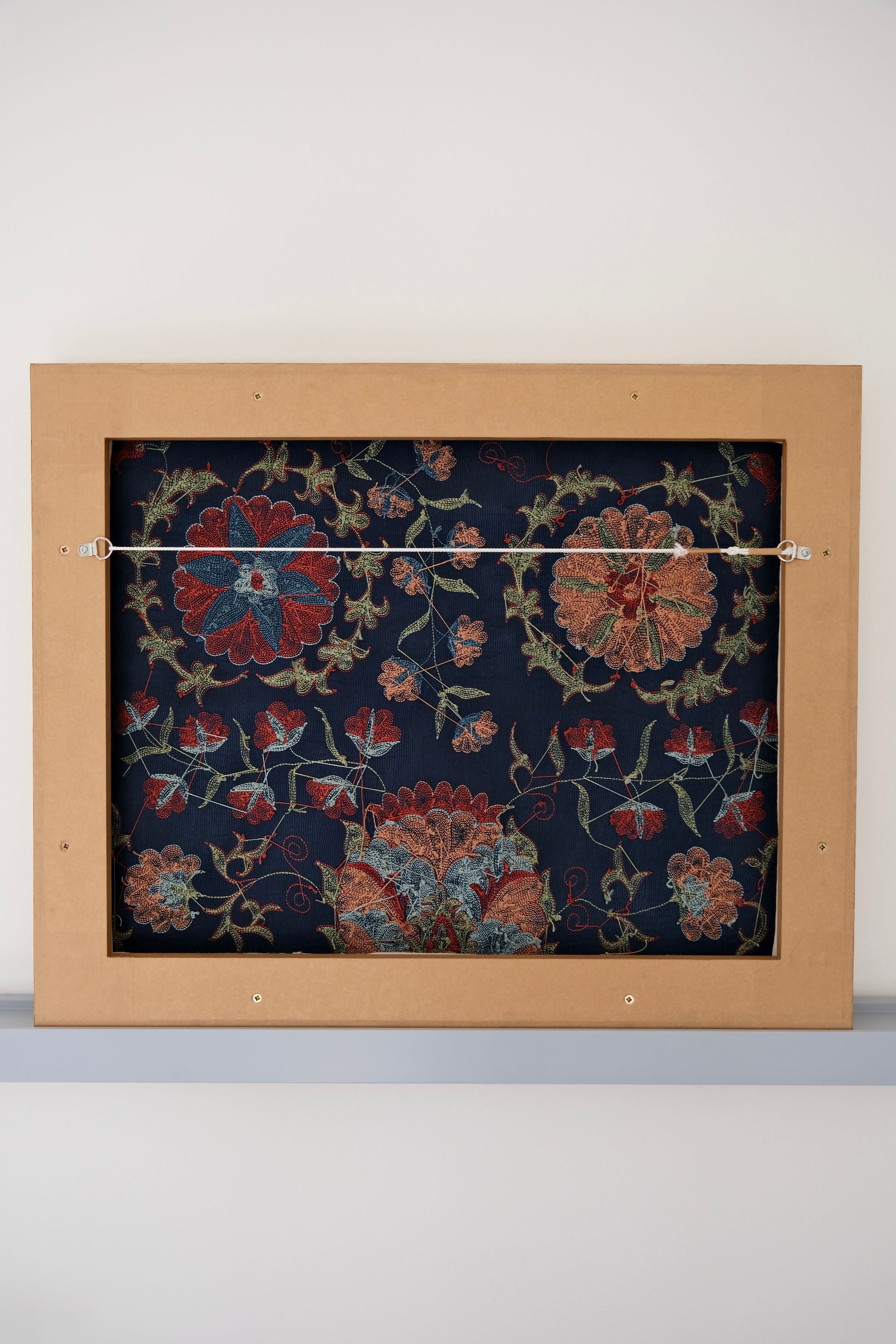 Framed suzani, embroidered textile art, wooden frame, navy blue with floral motifs, backside