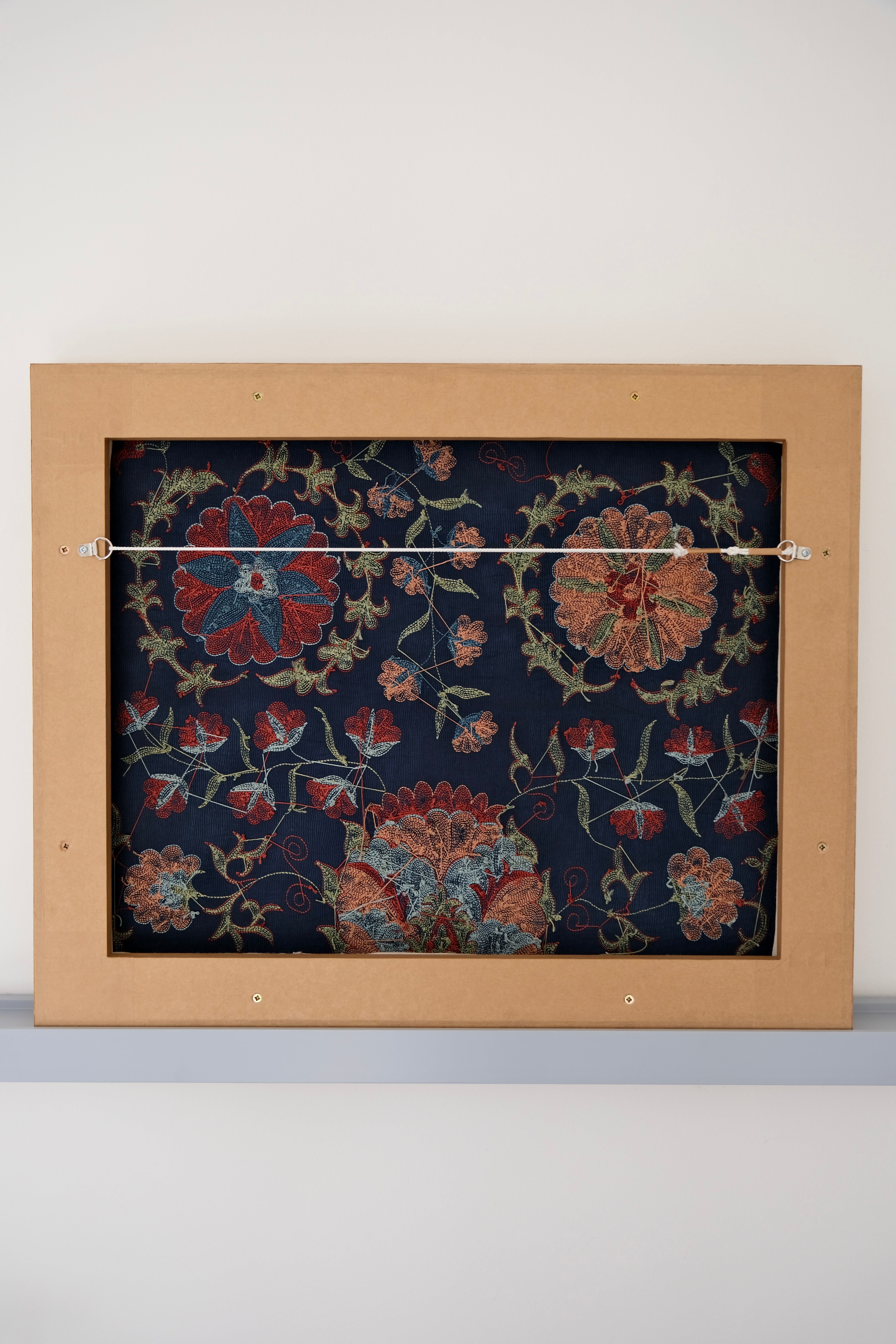 Framed suzani, embroidered textile art, wooden frame, navy blue with floral motifs, backside