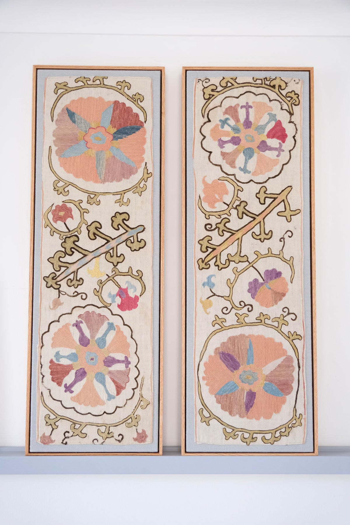 Pair of framed antique suzanis, pastel colours
