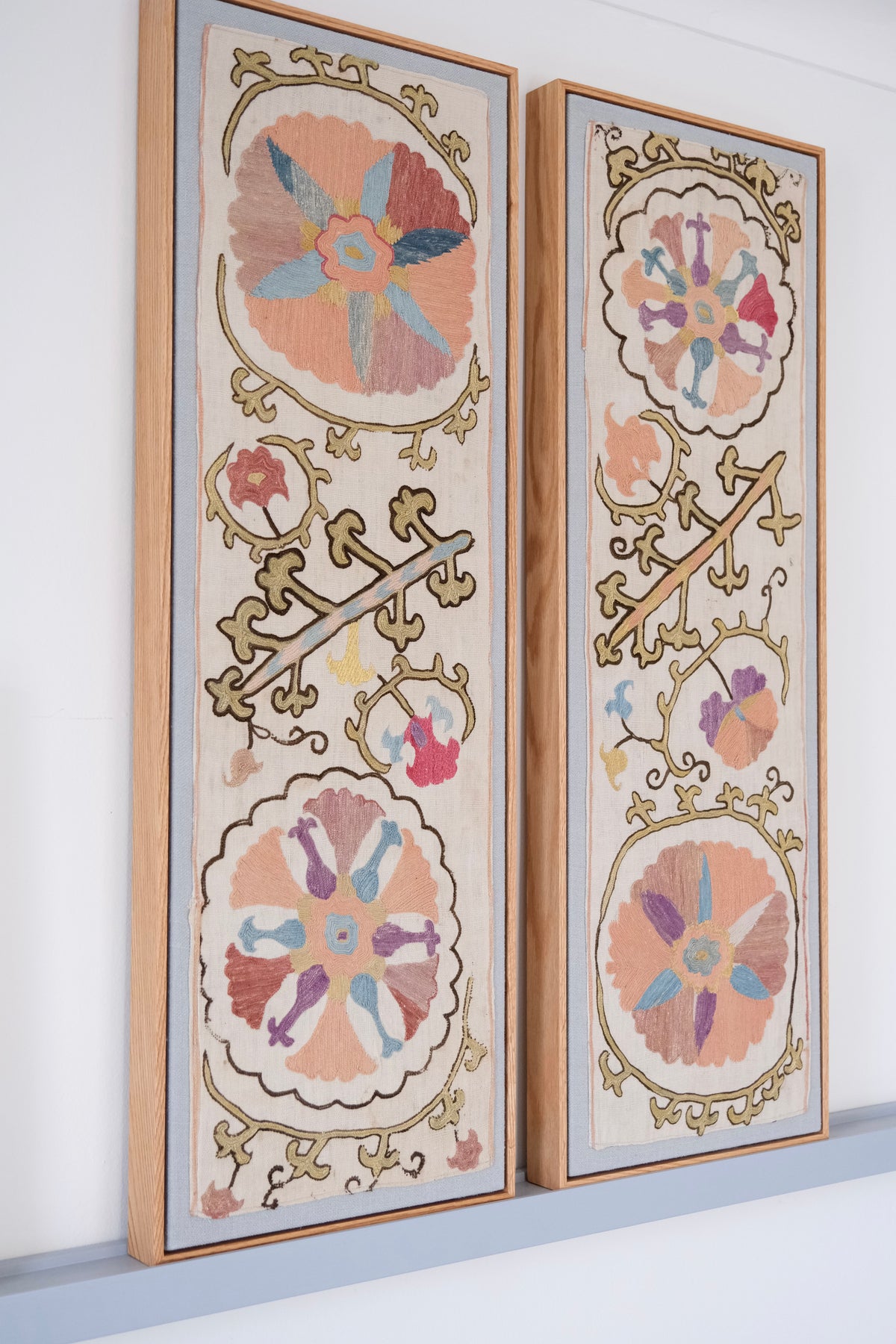 Pair of framed antique suzanis, pastel colours