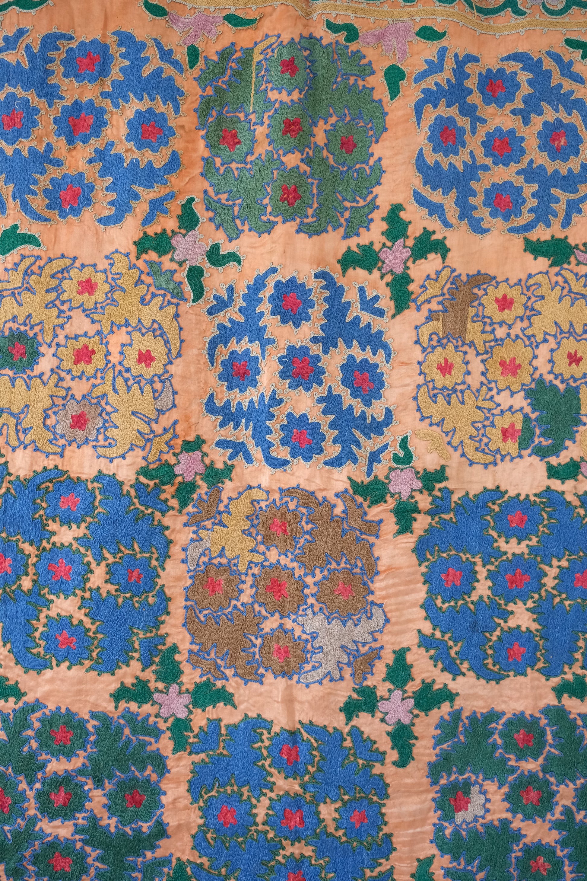 Vintage suzani, silk embroidered textile, orange and floral design, close-up