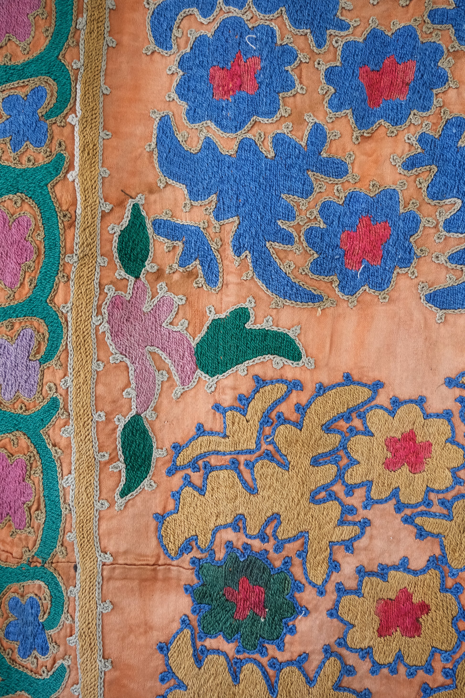 Vintage suzani, silk embroidered textile, orange and floral design, close-up