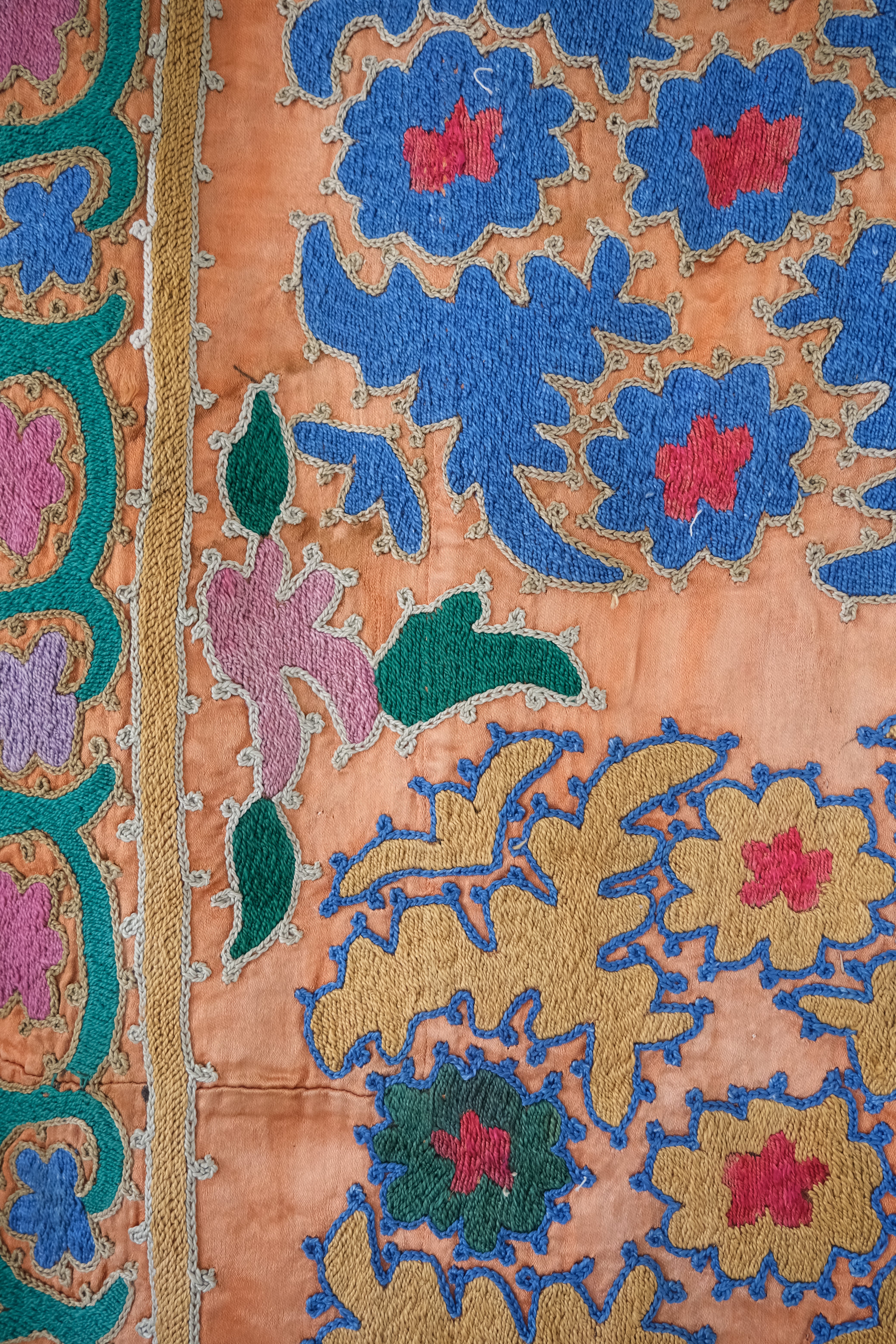 Vintage suzani, silk embroidered textile, orange and floral design, close-up