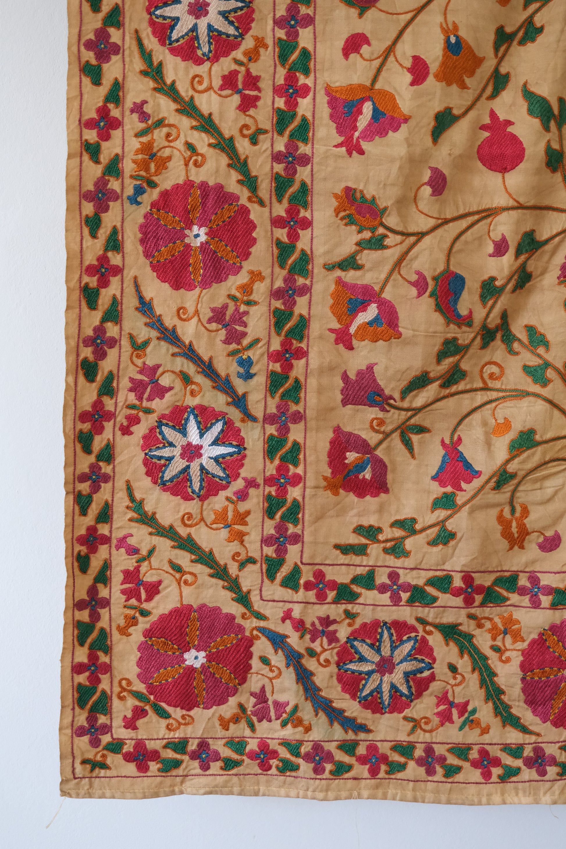 Antique suzani wallhanging, embroidered antique textile, camel with pink florals, close-up