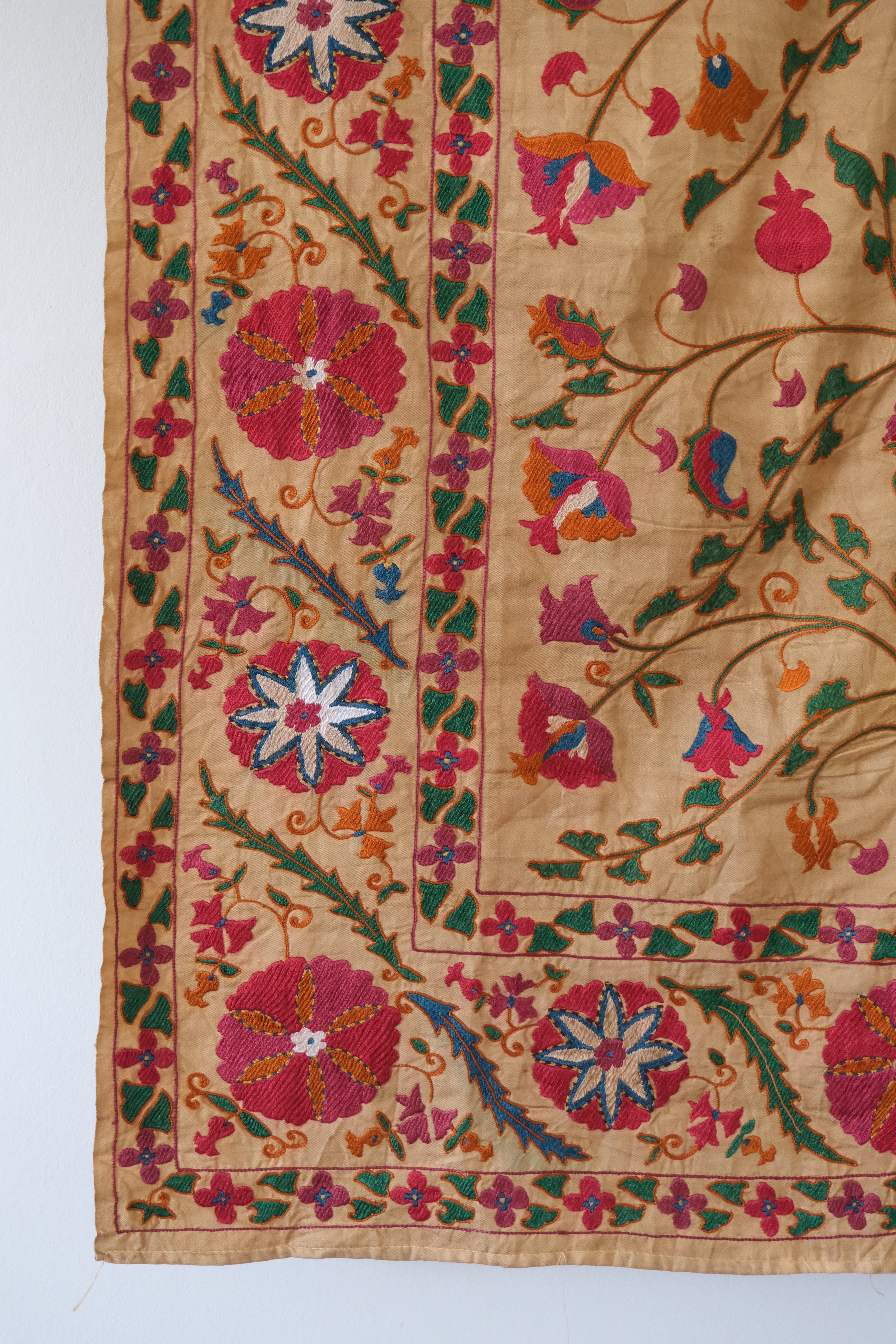 Antique suzani wallhanging, embroidered antique textile, camel with pink florals, close-up