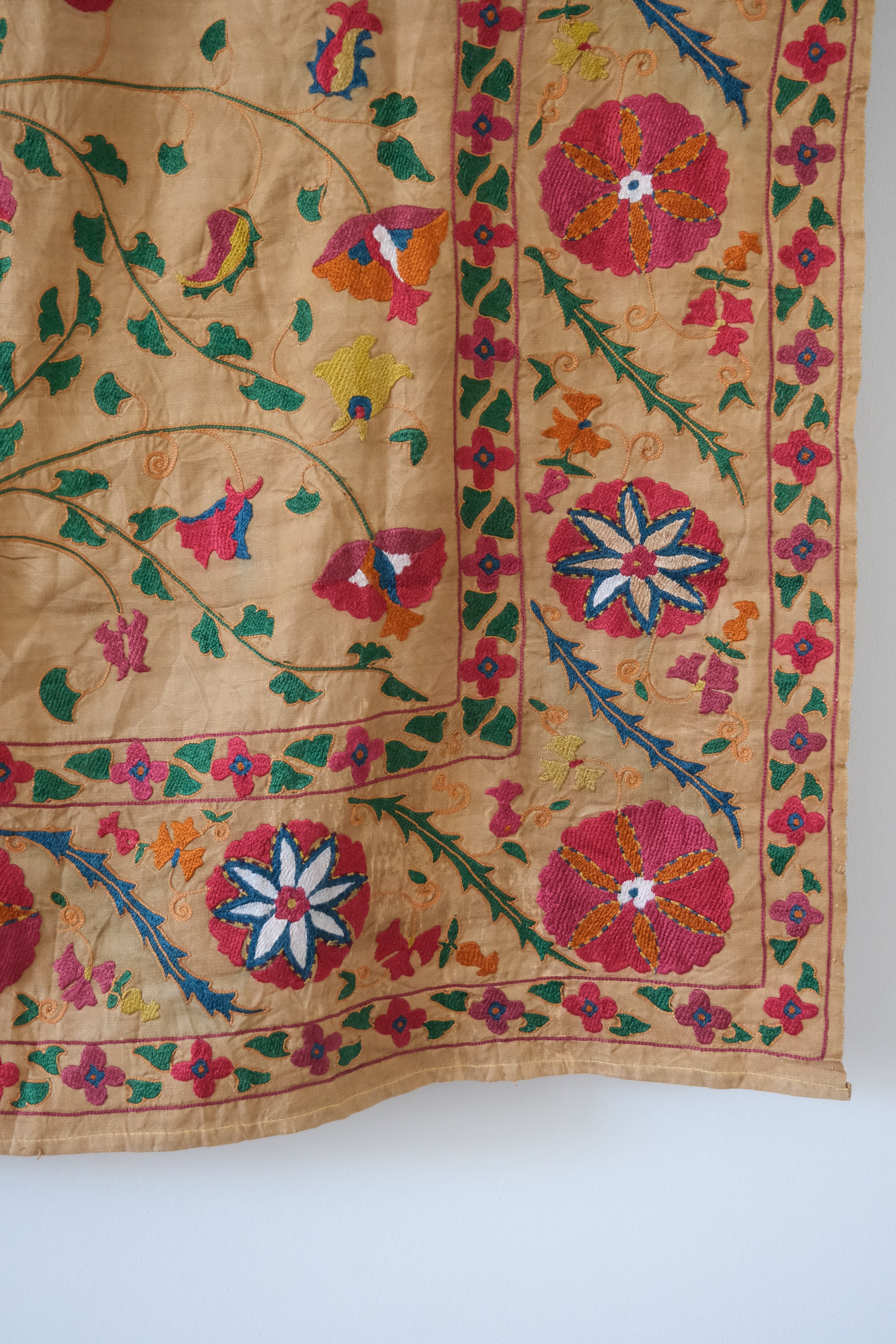 Antique suzani wallhanging, embroidered antique textile, camel with pink florals, close-up