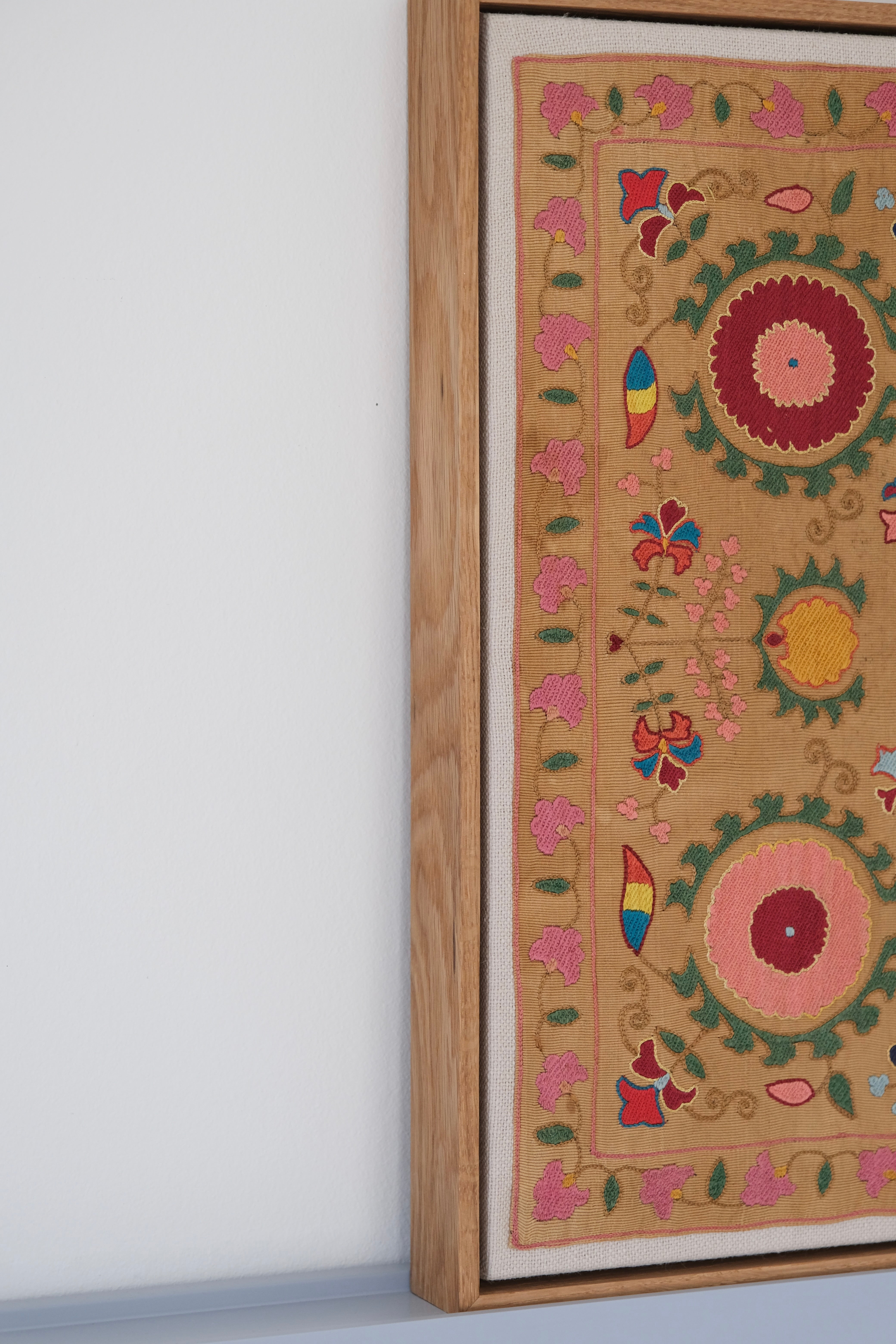 Framed antique suzani, framed textile, embroidered textile art, wooden frame, side view