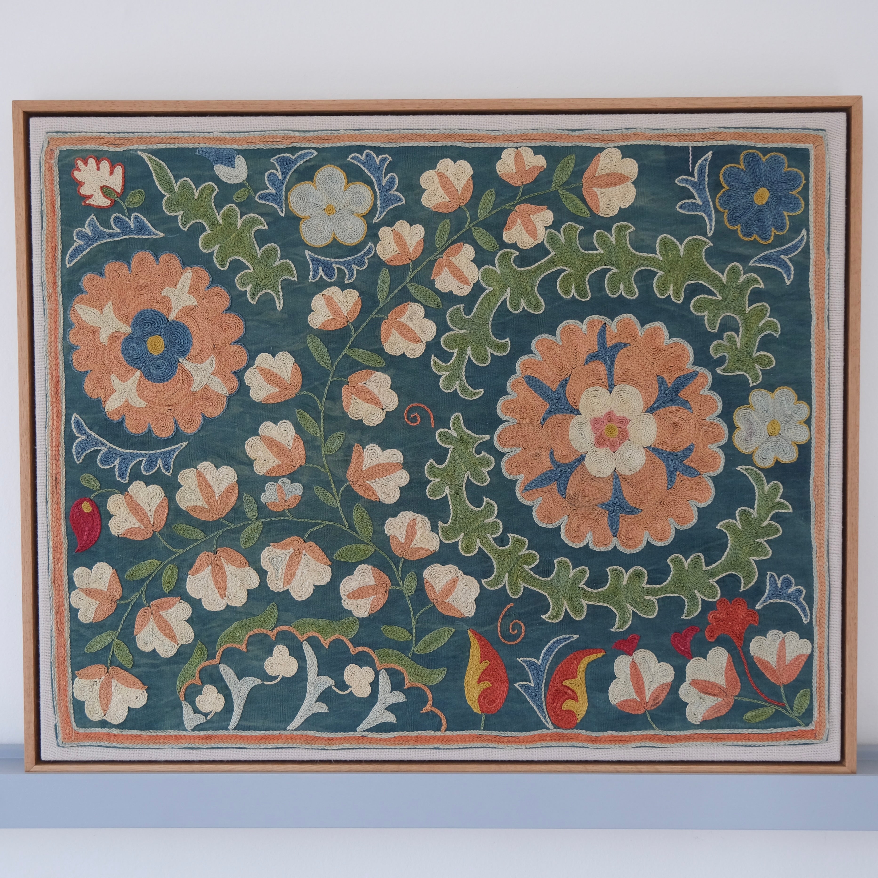 Framed suzani, embroidered textile art, wooden frame, green with orange and blue floral motifs