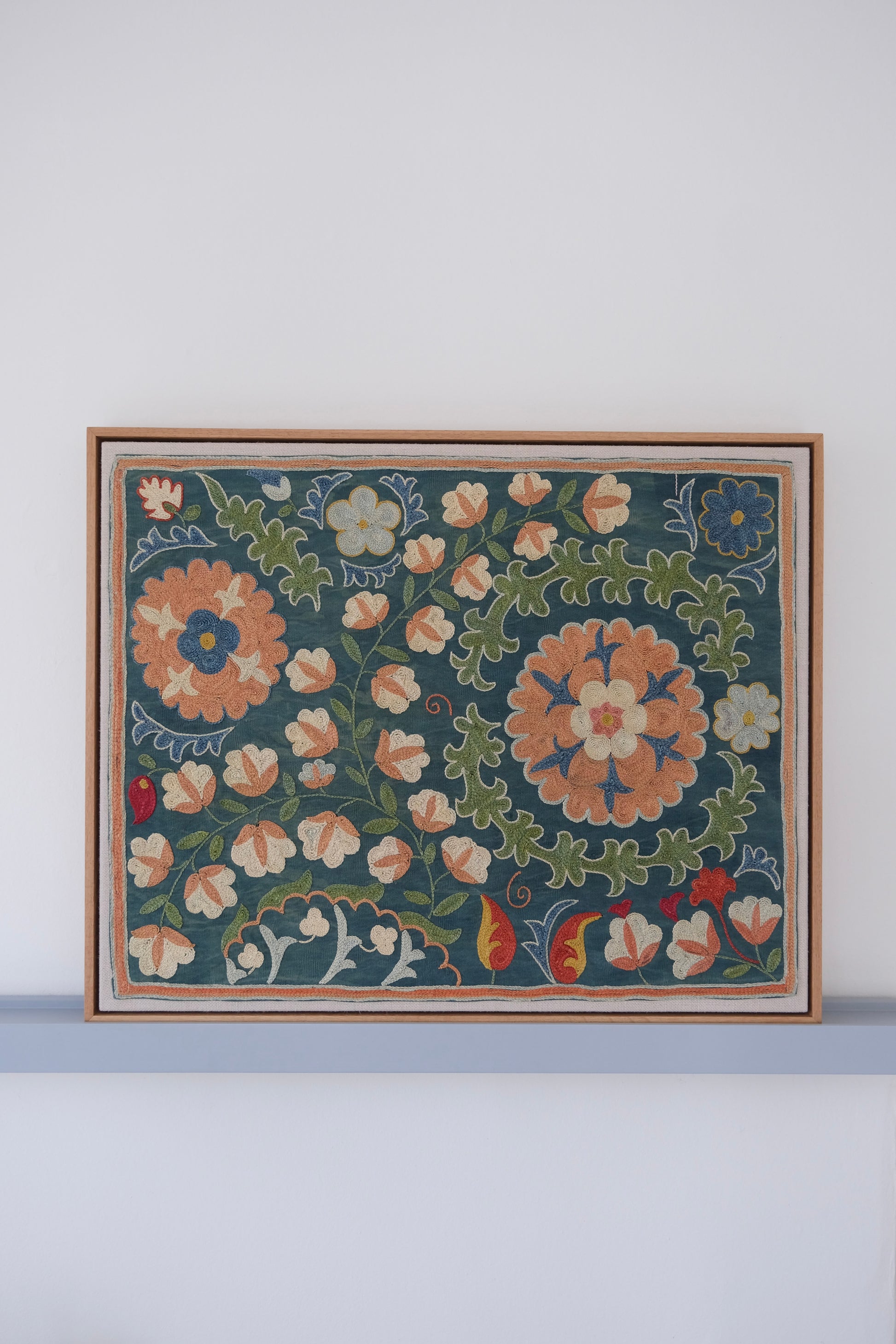 Framed suzani, embroidered textile art, wooden frame, green with orange and blue floral motifs
