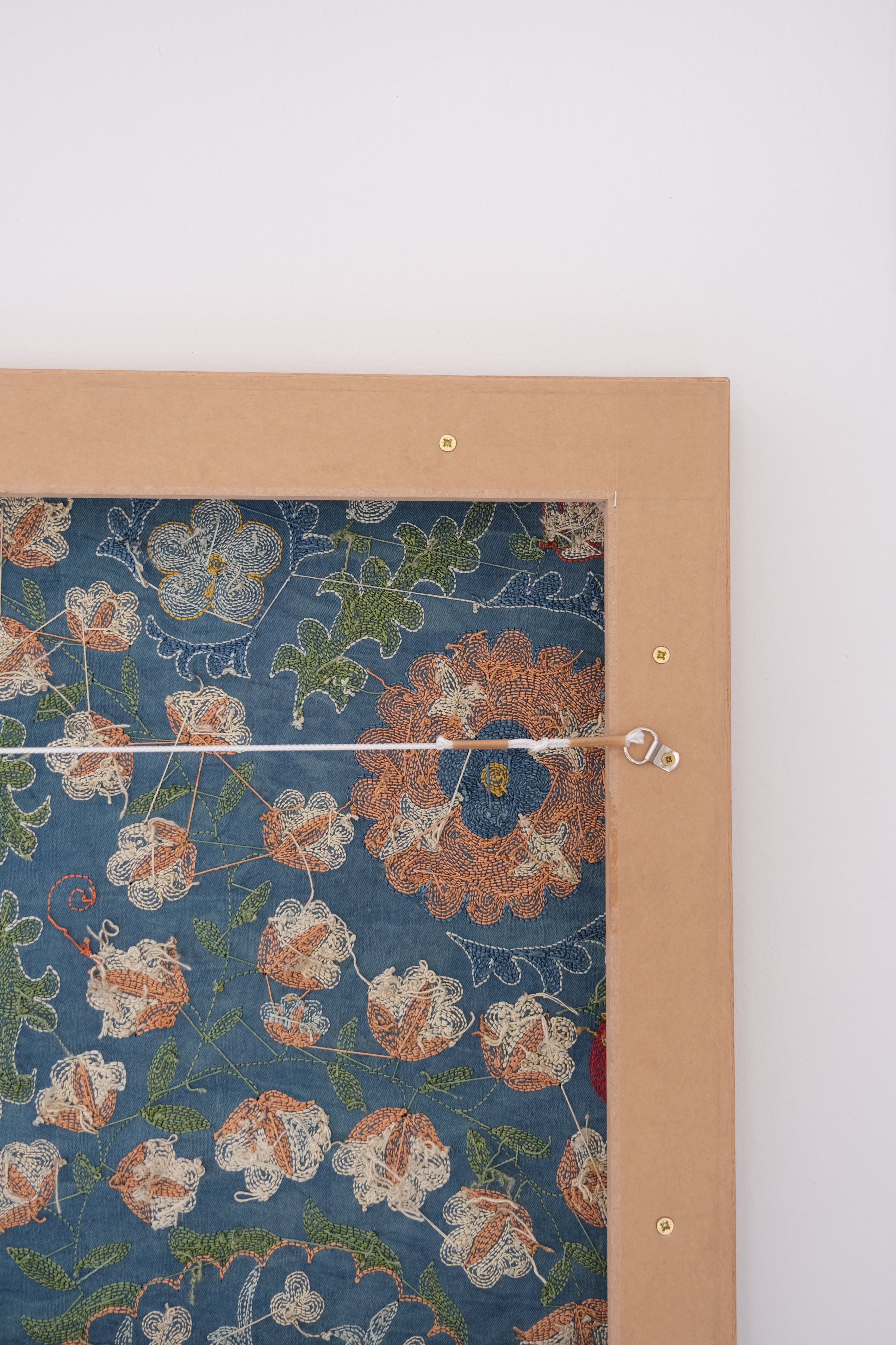 Framed suzani, embroidered textile art, wooden frame, green with orange and blue floral motifs, backside