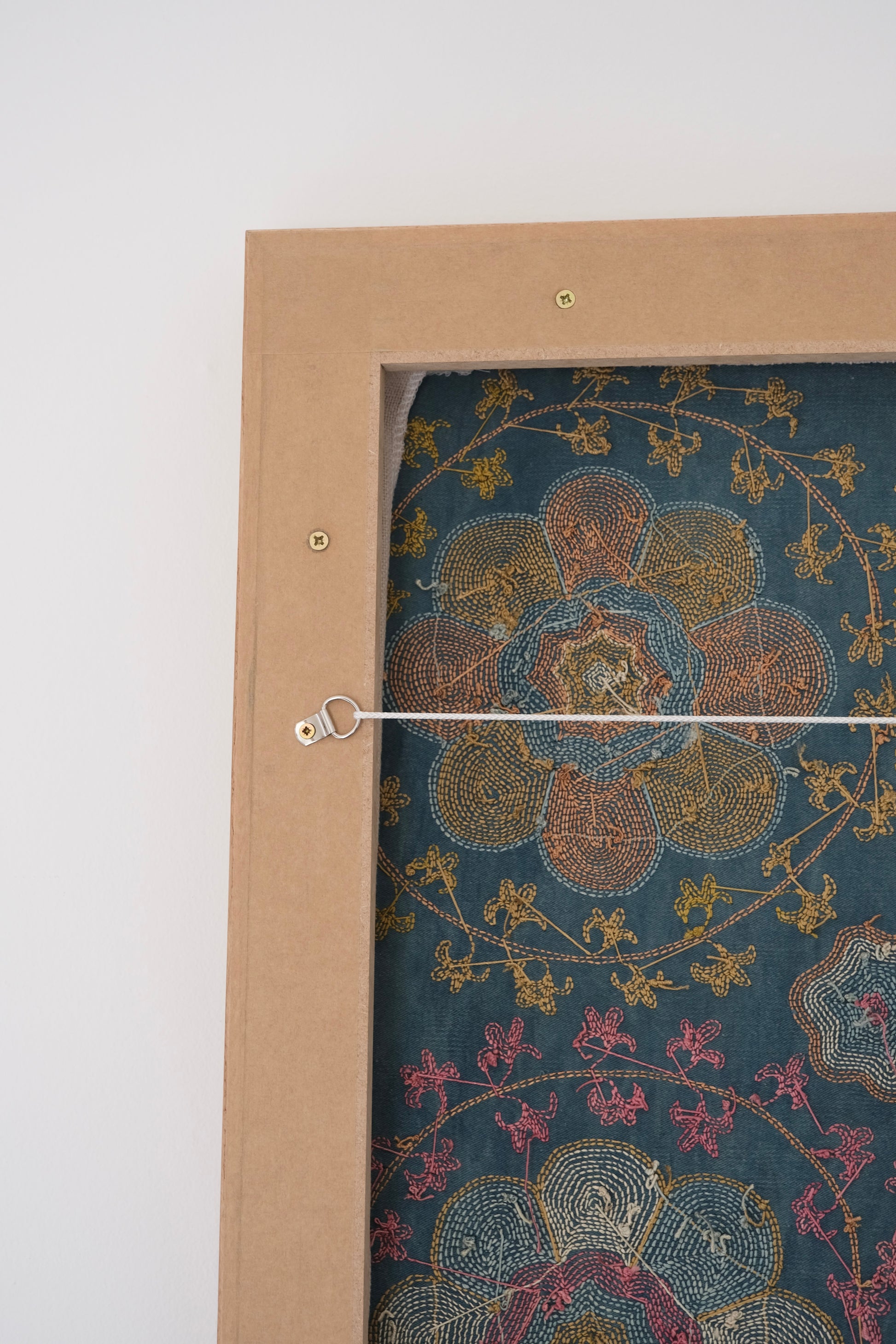 Framed suzani, embroidered textile art, wooden frame, green with orange and pink floral motifs, backside