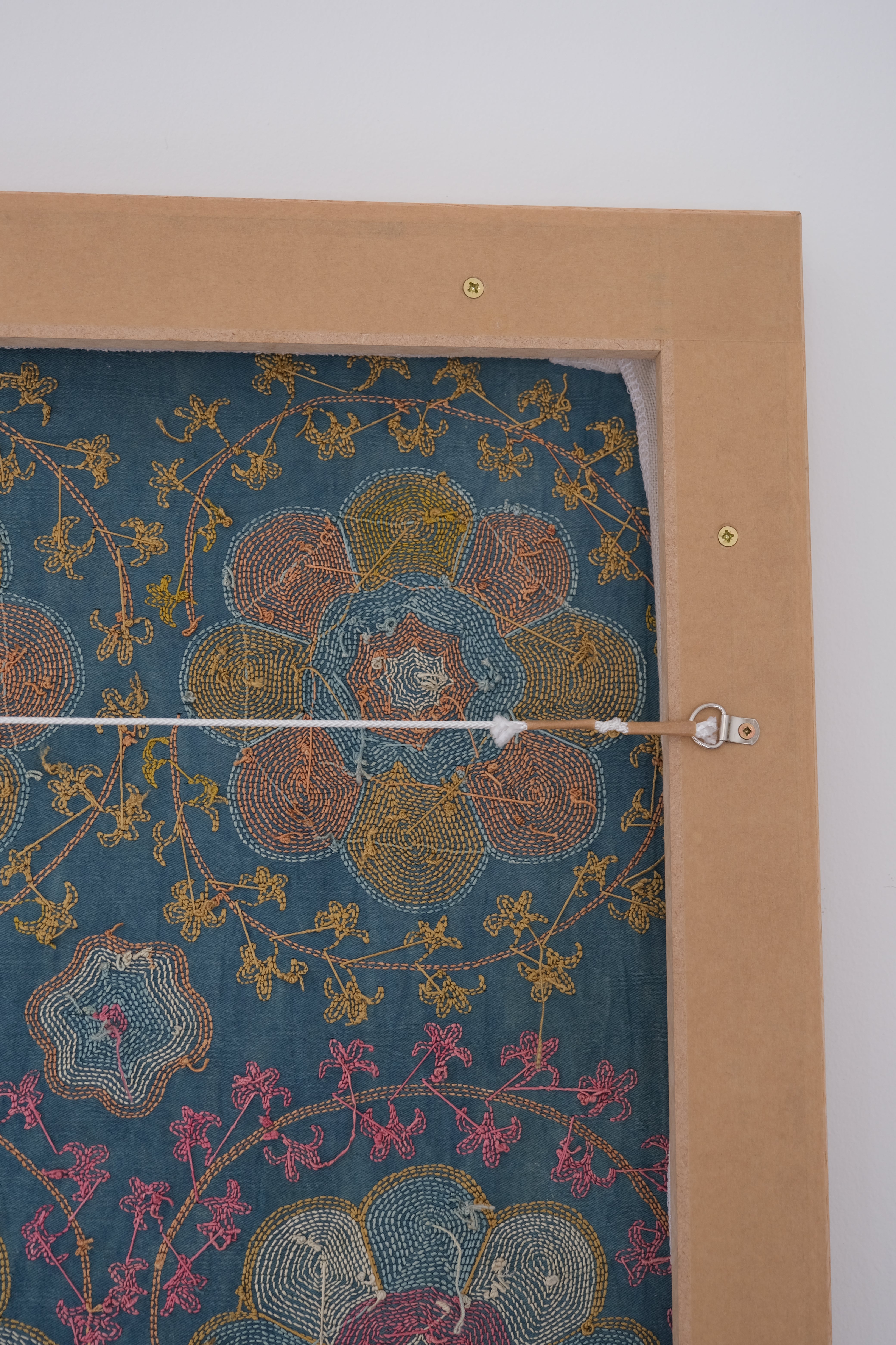 Framed suzani, embroidered textile art, wooden frame, green with orange and pink floral motifs, backside