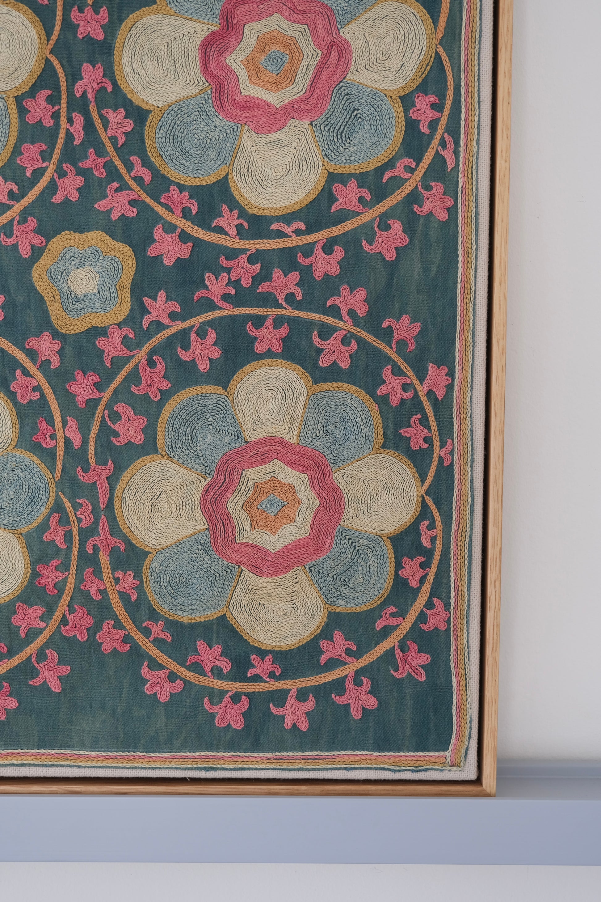 Framed suzani, embroidered textile art, wooden frame, green with florals, close-up
