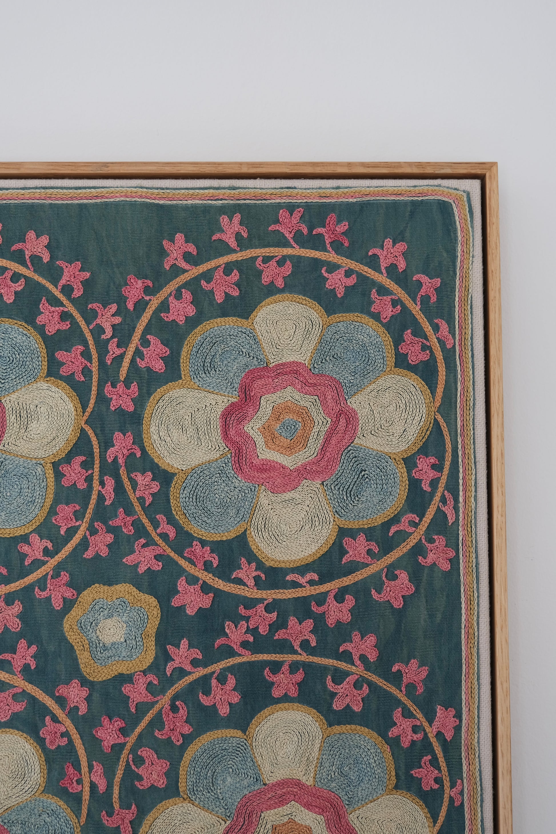 Framed suzani, embroidered textile art, wooden frame, green with florals, close-up