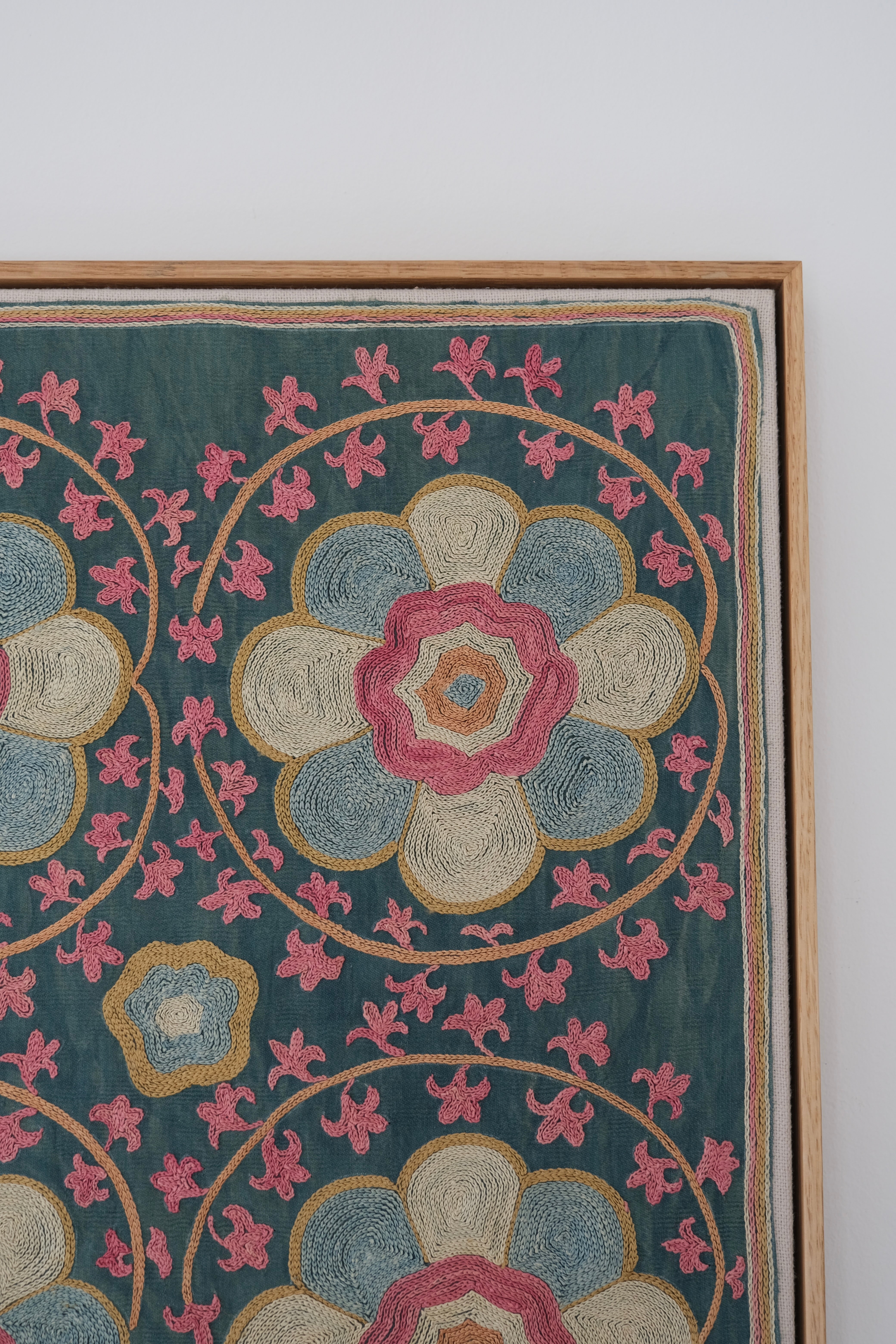 Framed suzani, embroidered textile art, wooden frame, green with florals, close-up
