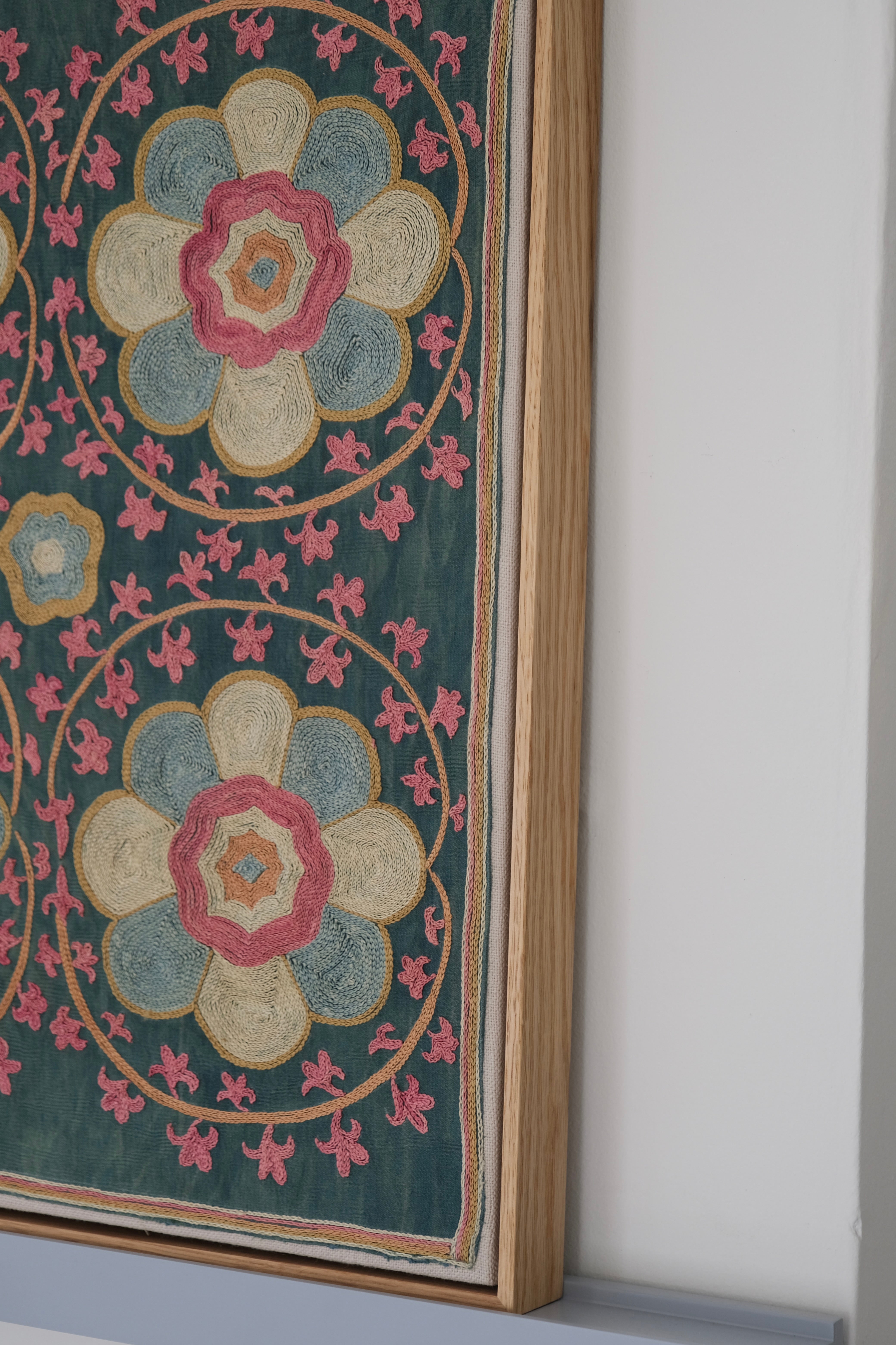 Framed suzani, embroidered textile art, wooden frame, green with florals, side view