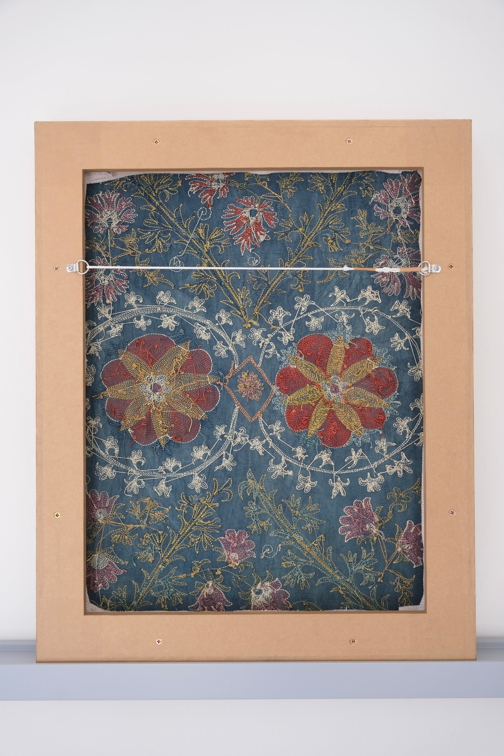 Framed suzani, embroidered textile art, wooden frame, green with floral motifs, backside