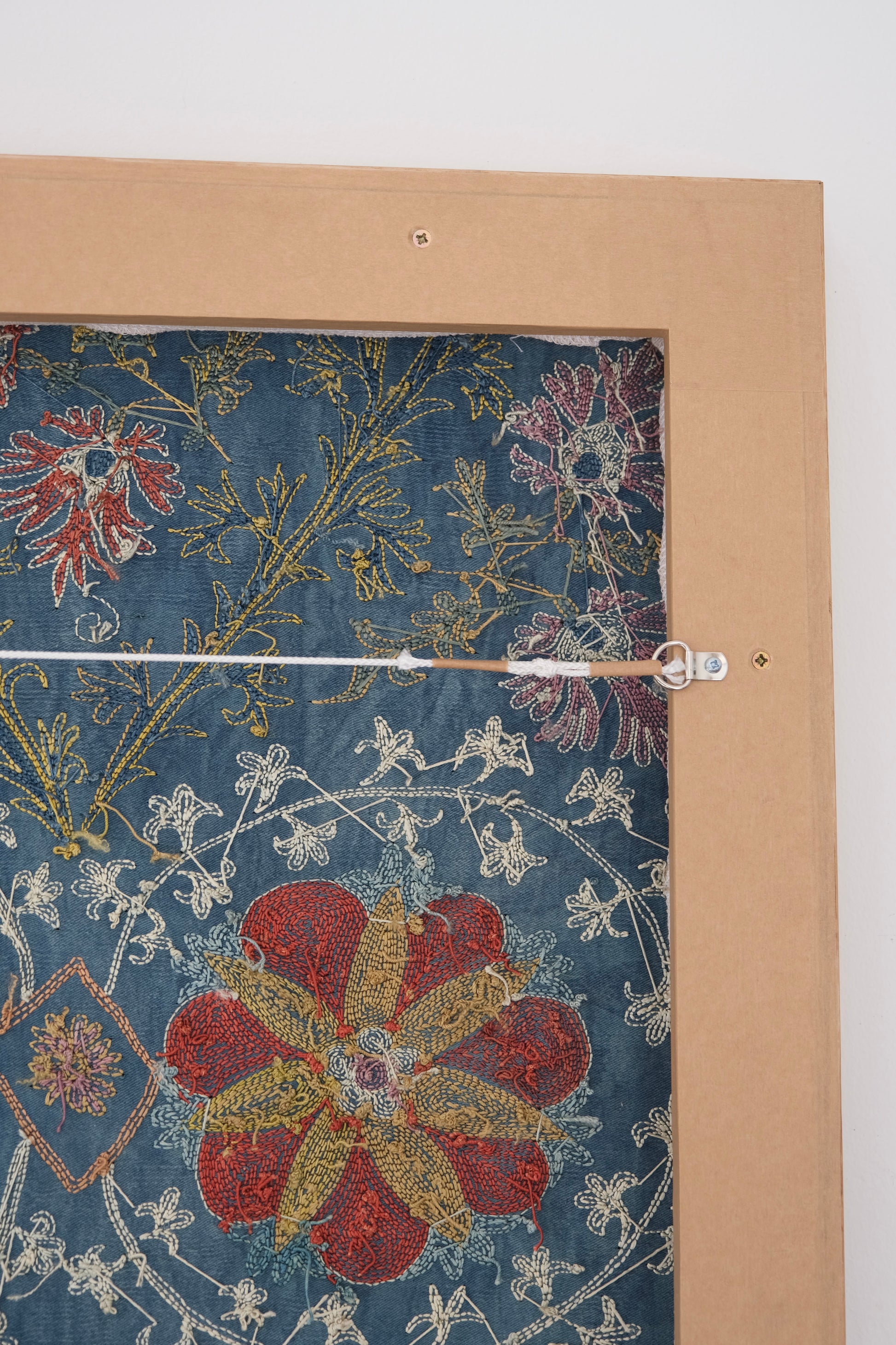 Framed suzani, embroidered textile art, wooden frame, green with floral motifs, backside
