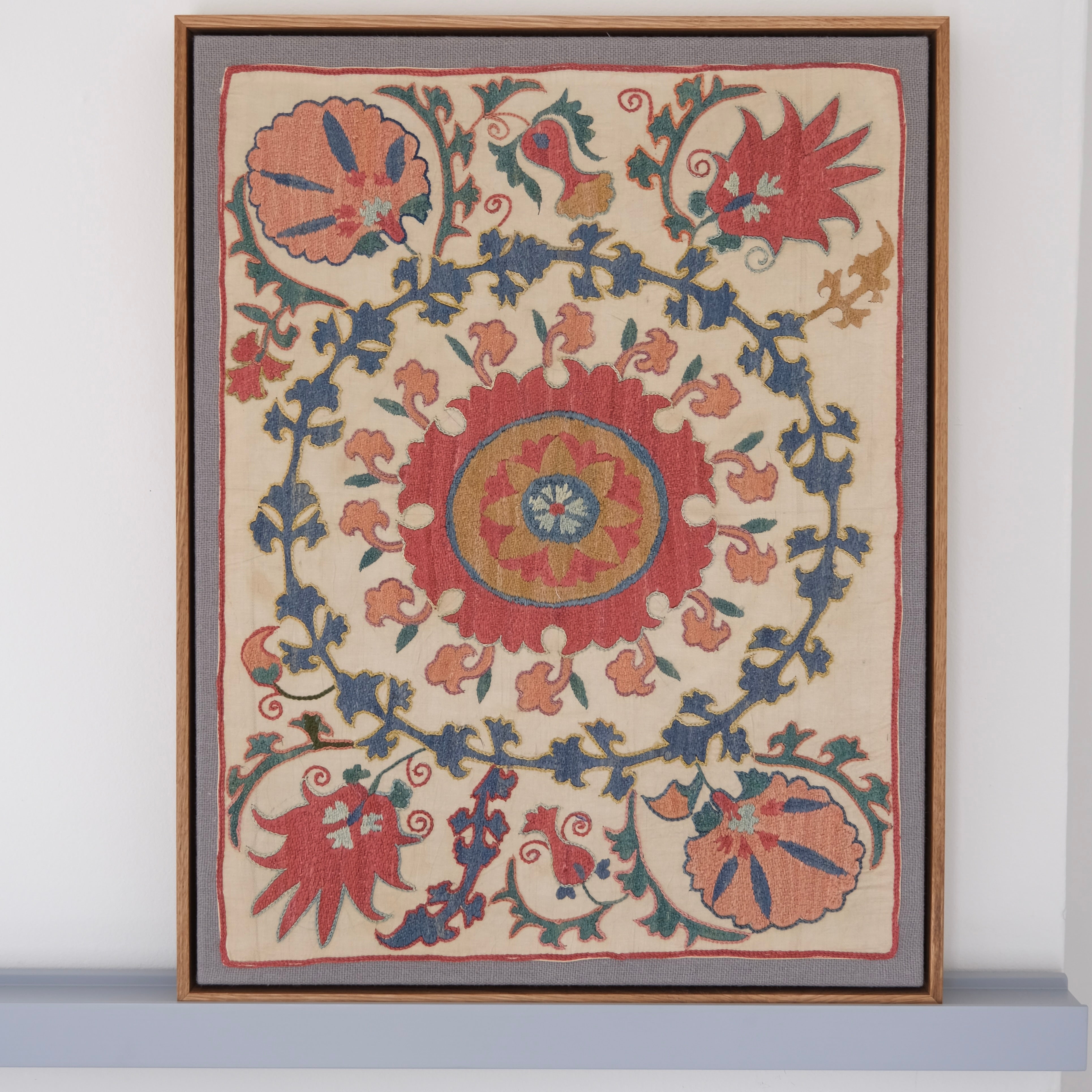 Framed suzani, embroidered textile art, wooden frame, white with pink and blue design
