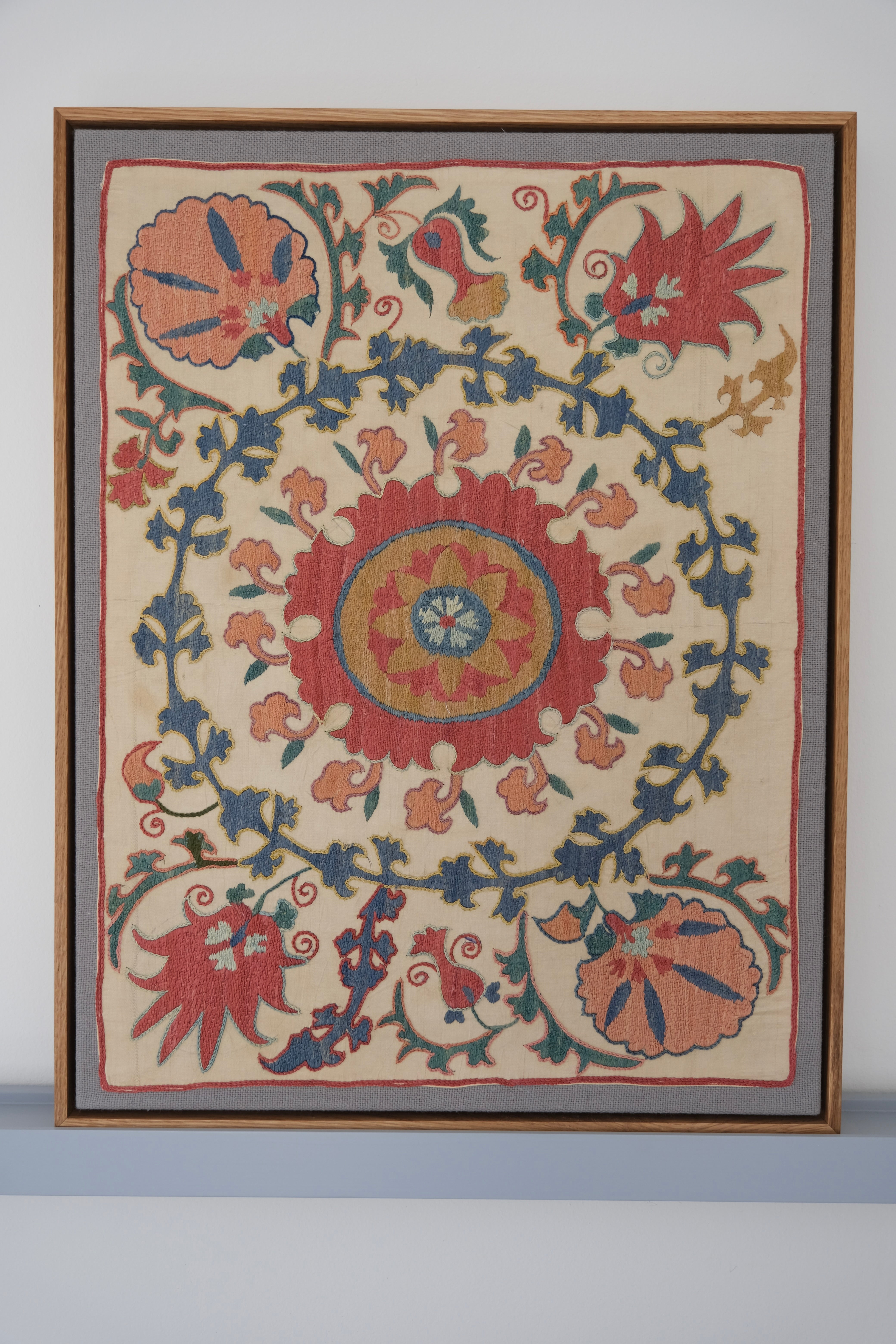 Framed suzani, embroidered textile art, wooden frame, white with pink and blue design