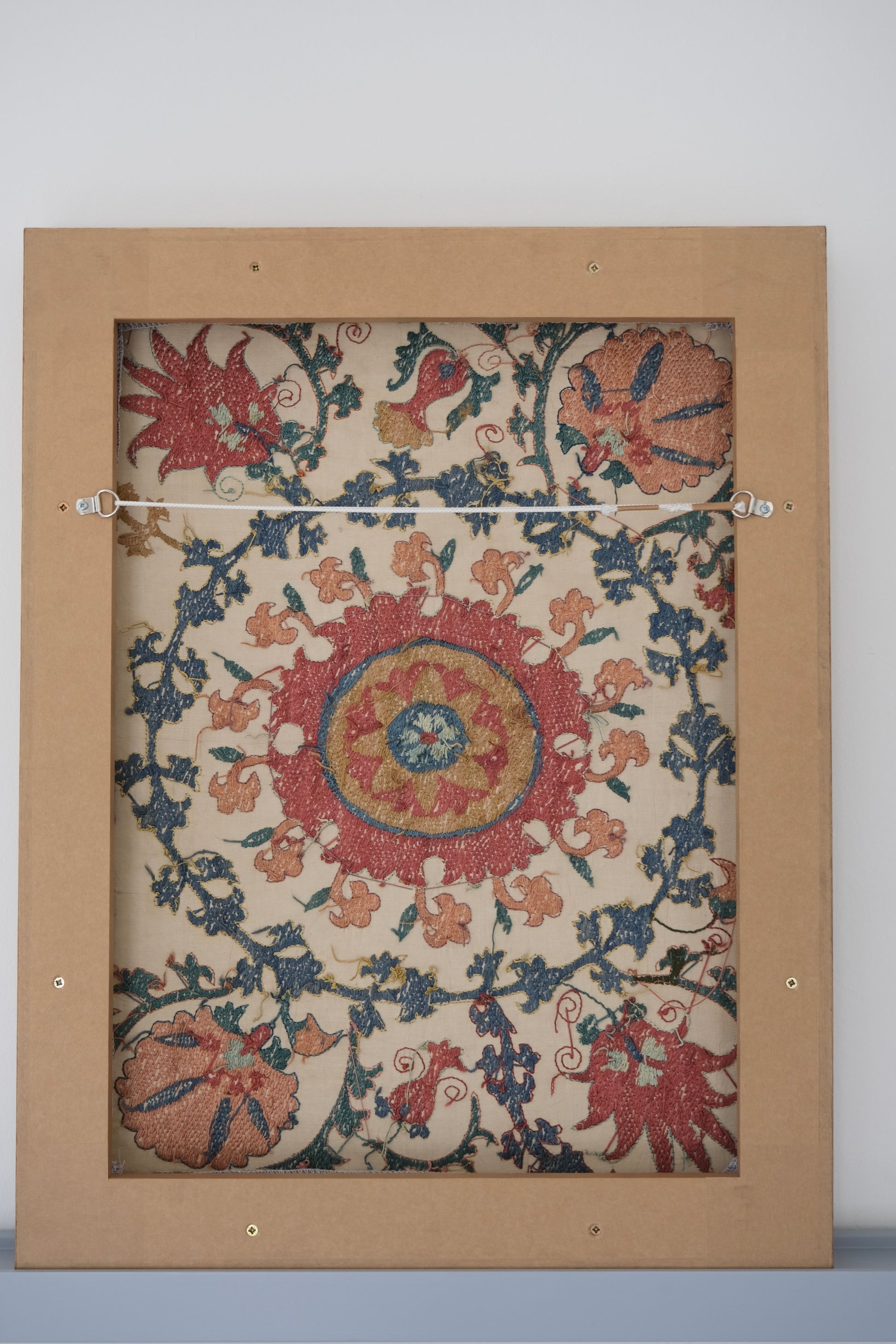 Framed suzani, embroidered textile art, wooden frame, white with pink and blue design, backside