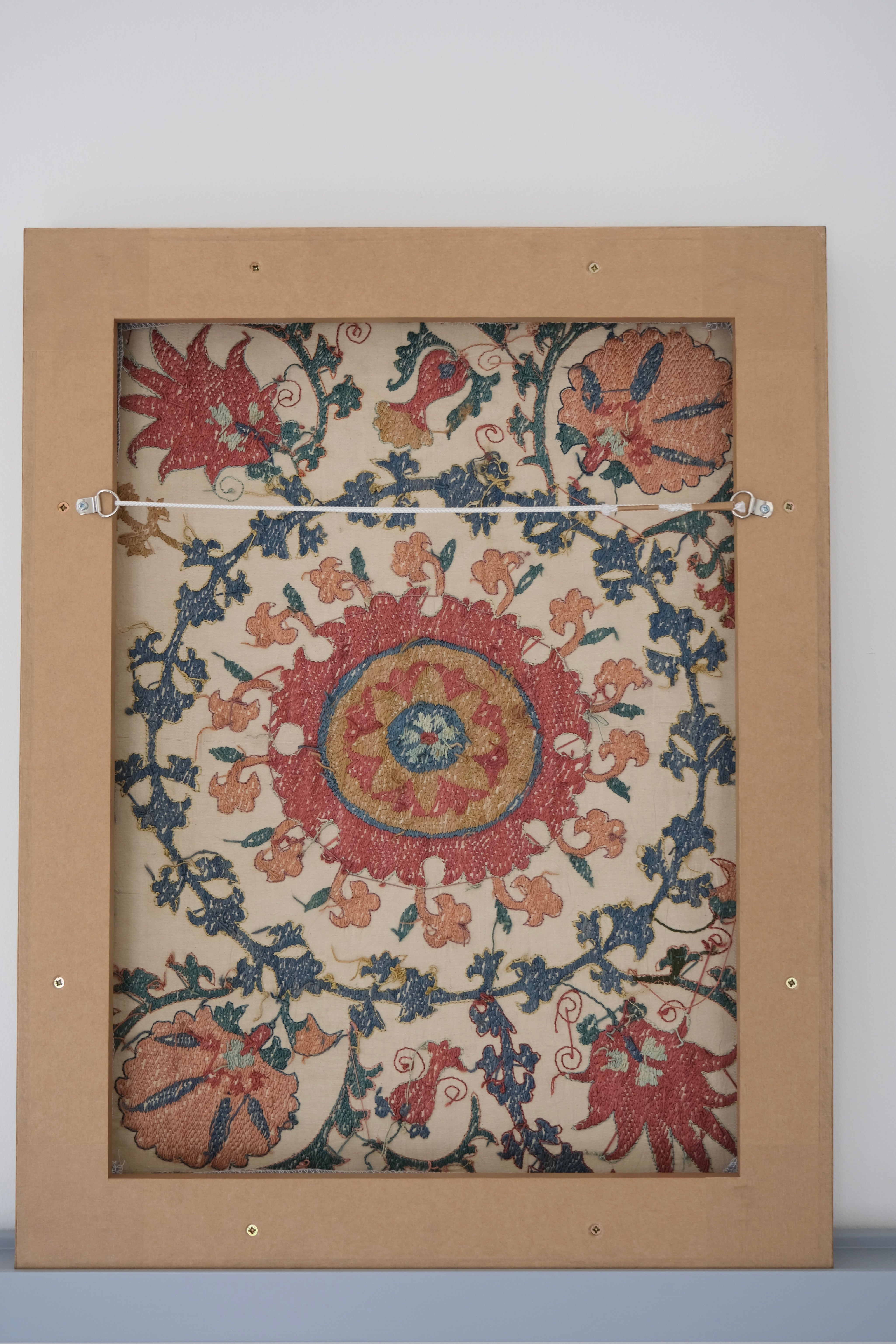 Framed suzani, embroidered textile art, wooden frame, white with pink and blue design, backside