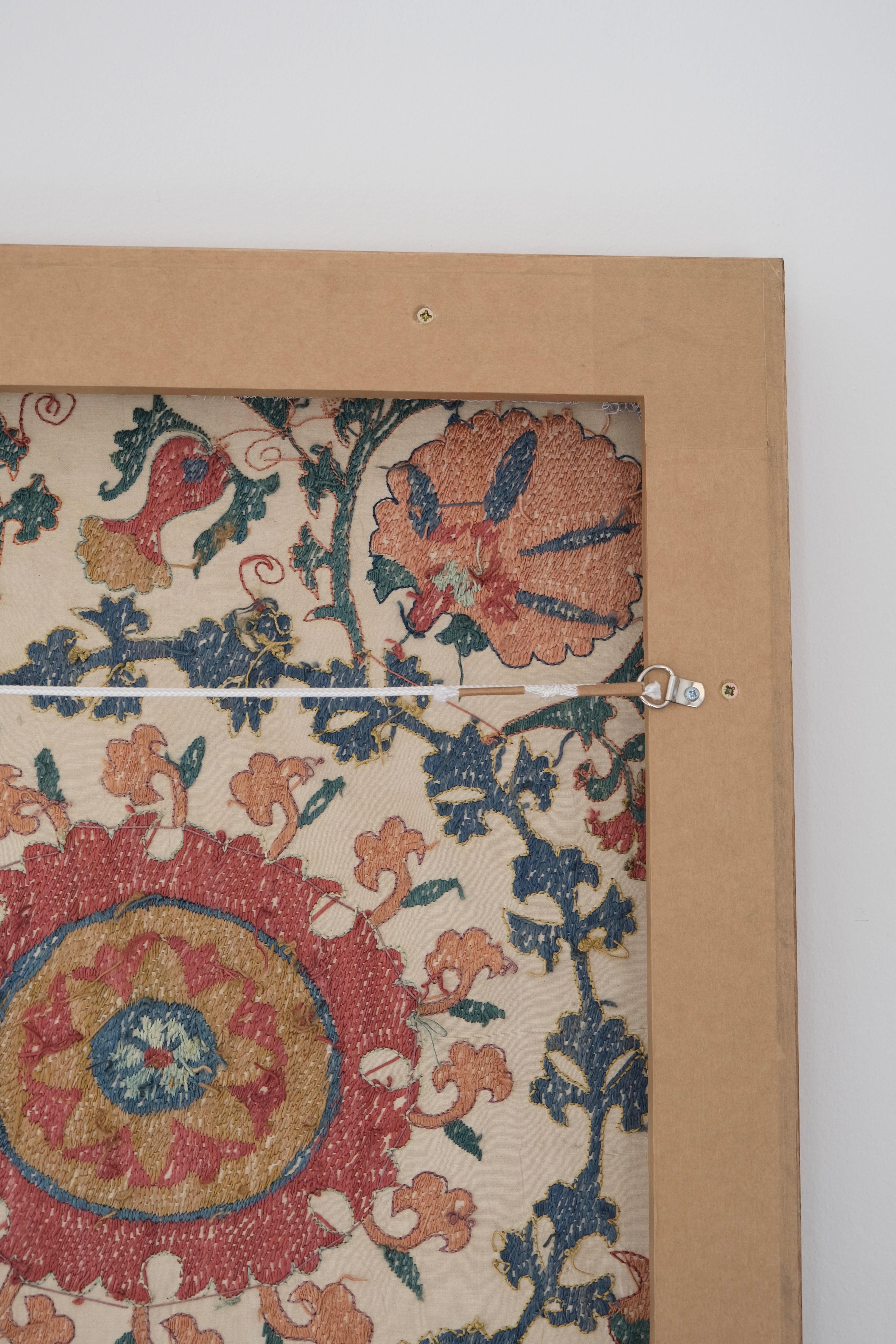 Framed suzani, embroidered textile art, wooden frame, white with pink and blue design, backside