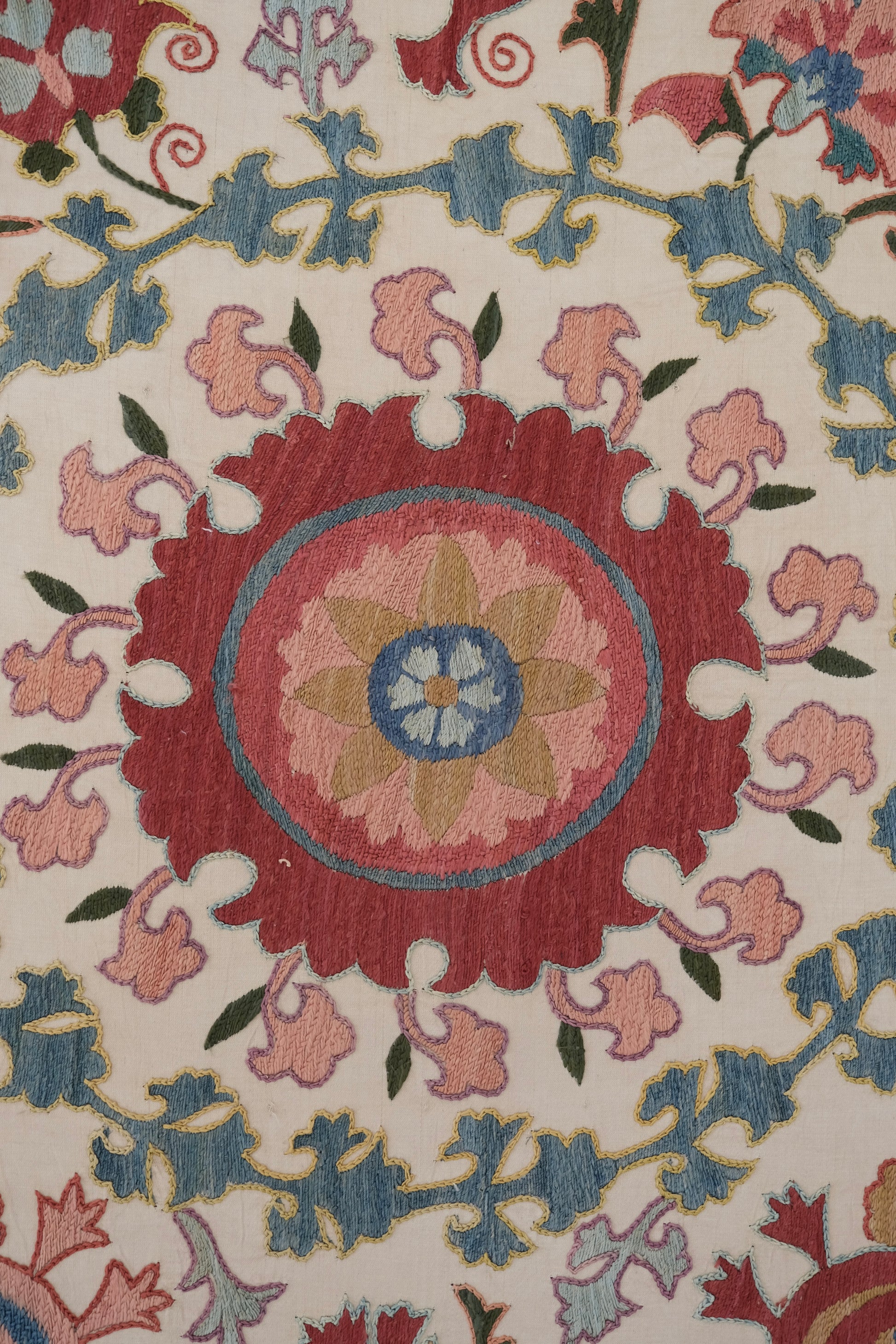 Framed suzani, embroidered textile art, wooden frame, white with pink and blue bird design, close-up