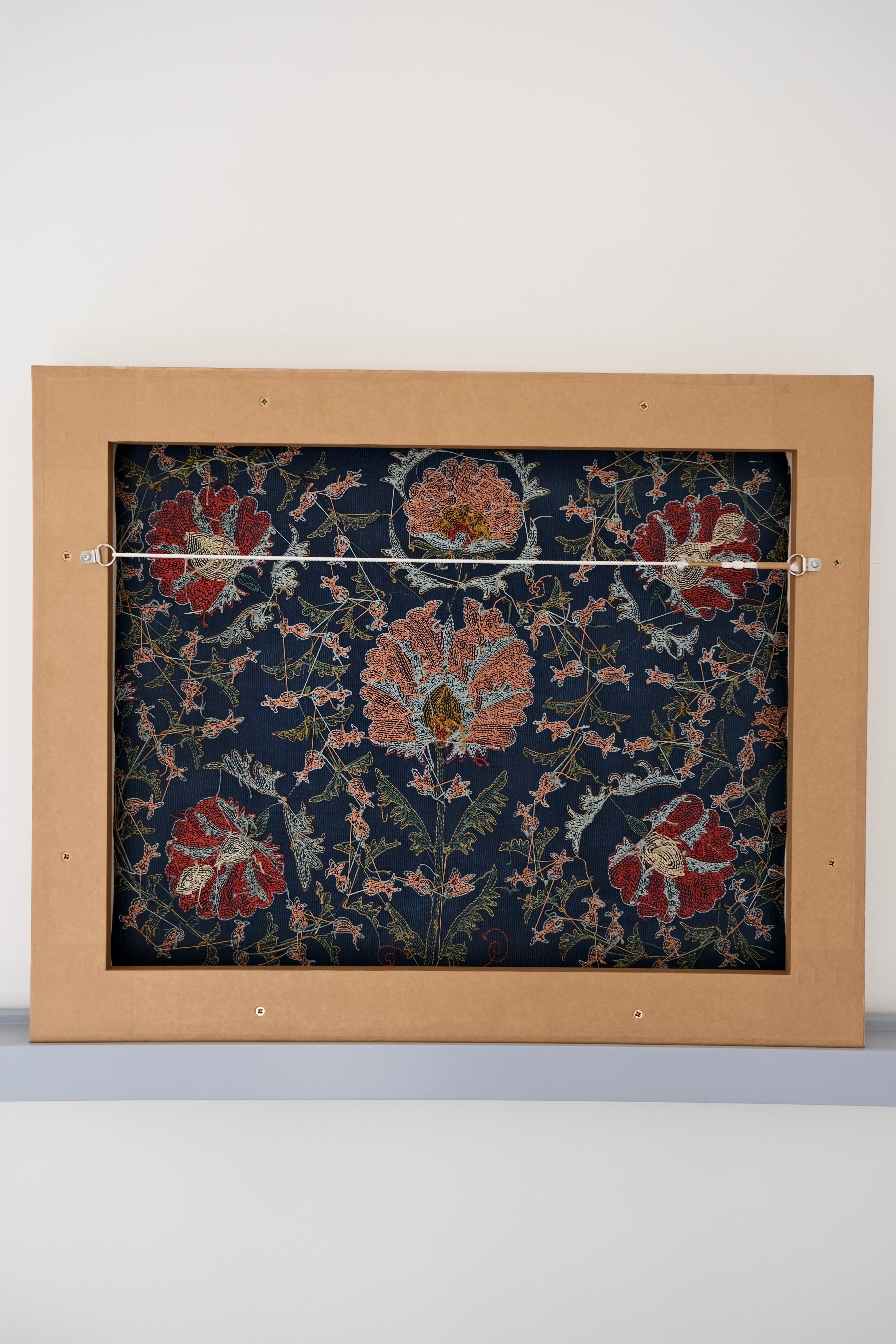 Framed suzani, embroidered textile art, wooden frame, navy blue with floral motifs, backside