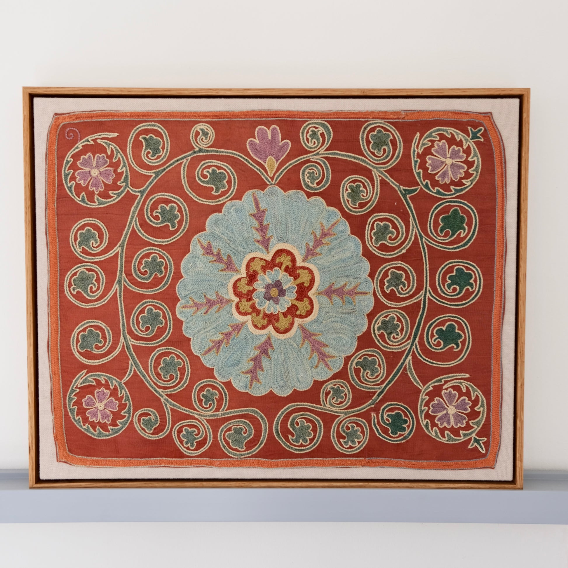 Framed suzani, embroidered textile art, wooden frame, dark orange and blue floral design