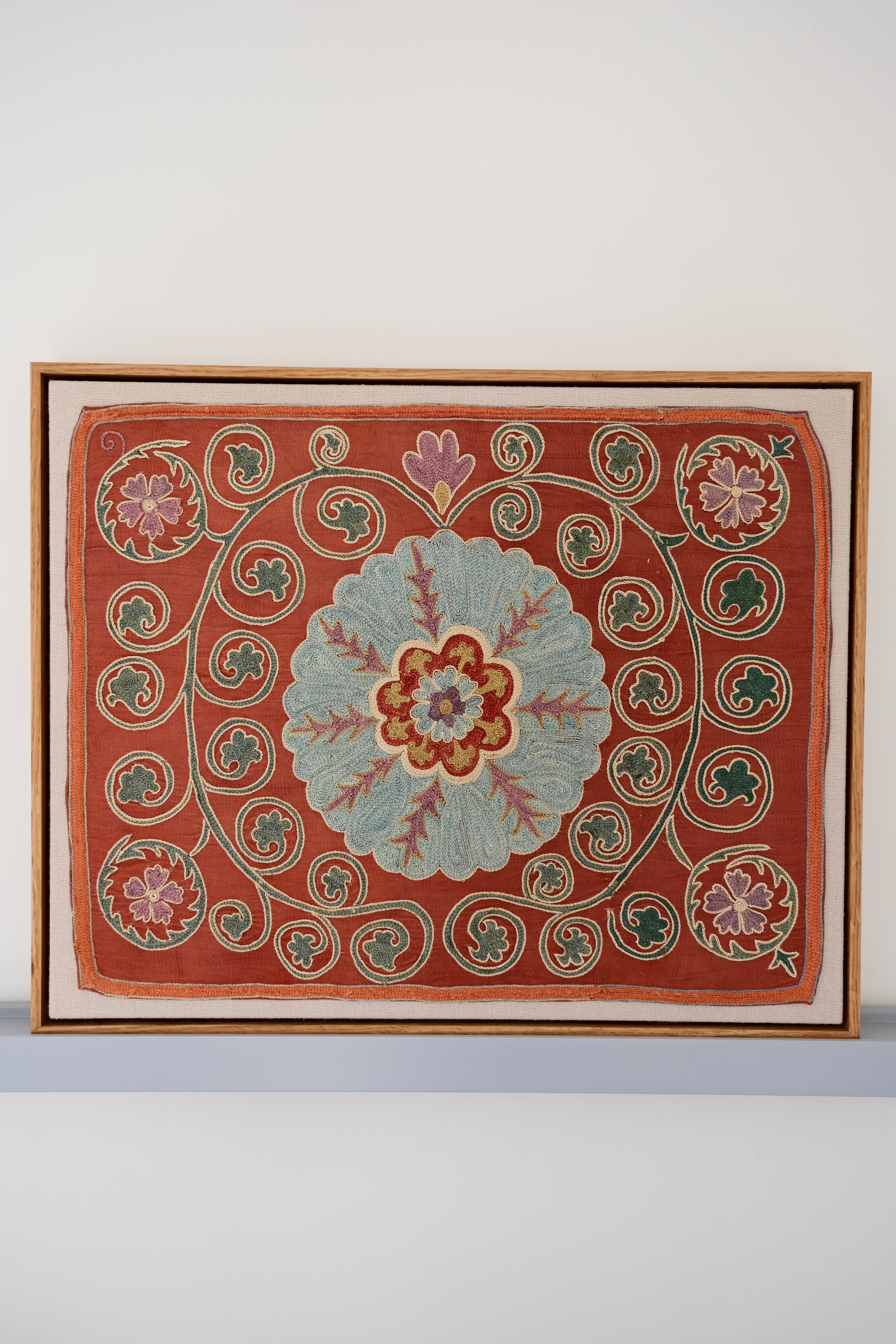 Framed suzani, embroidered textile art, wooden frame, dark orange and blue floral design