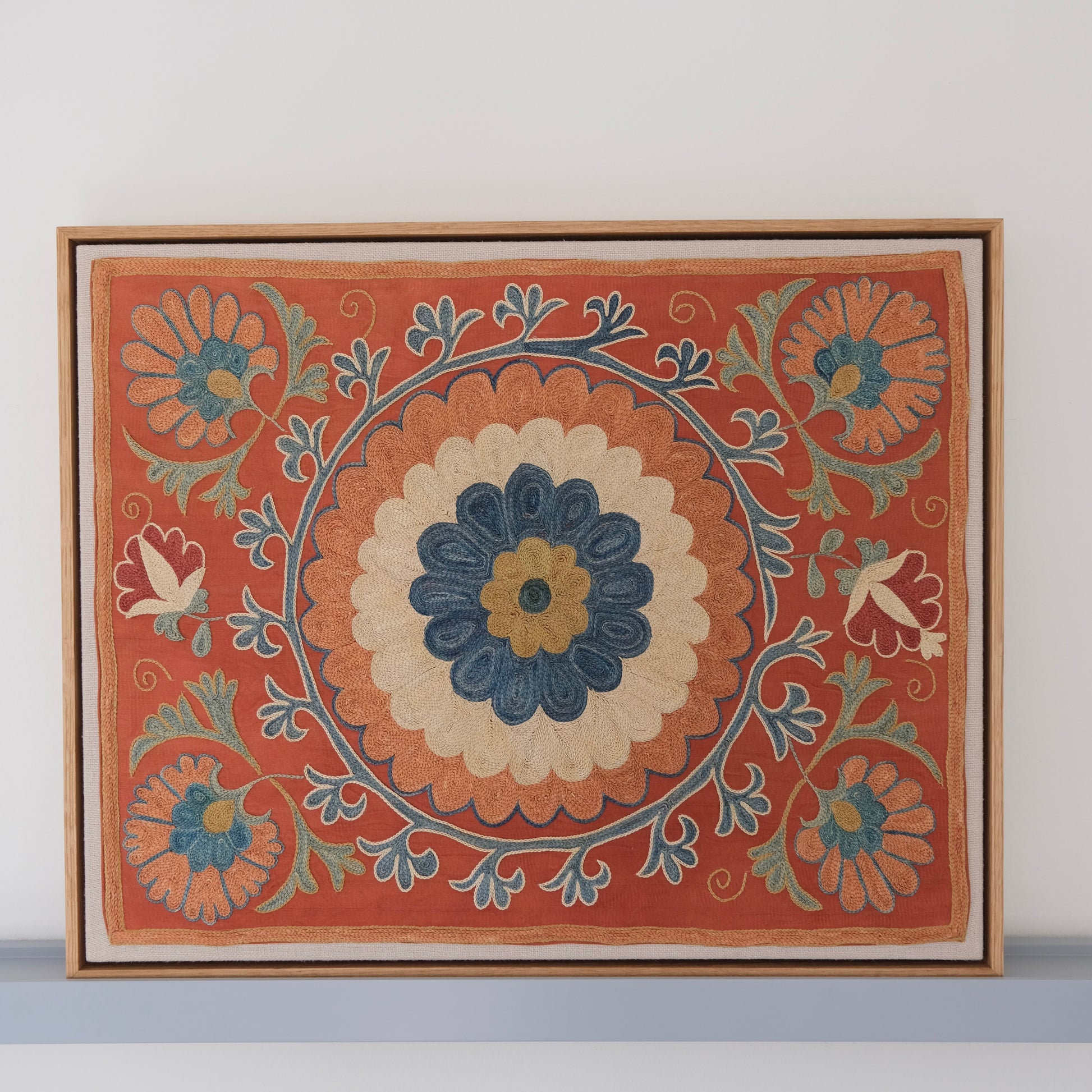 Framed suzani, embroidered textile art, wooden frame, dark orange with blue and green floral motifs