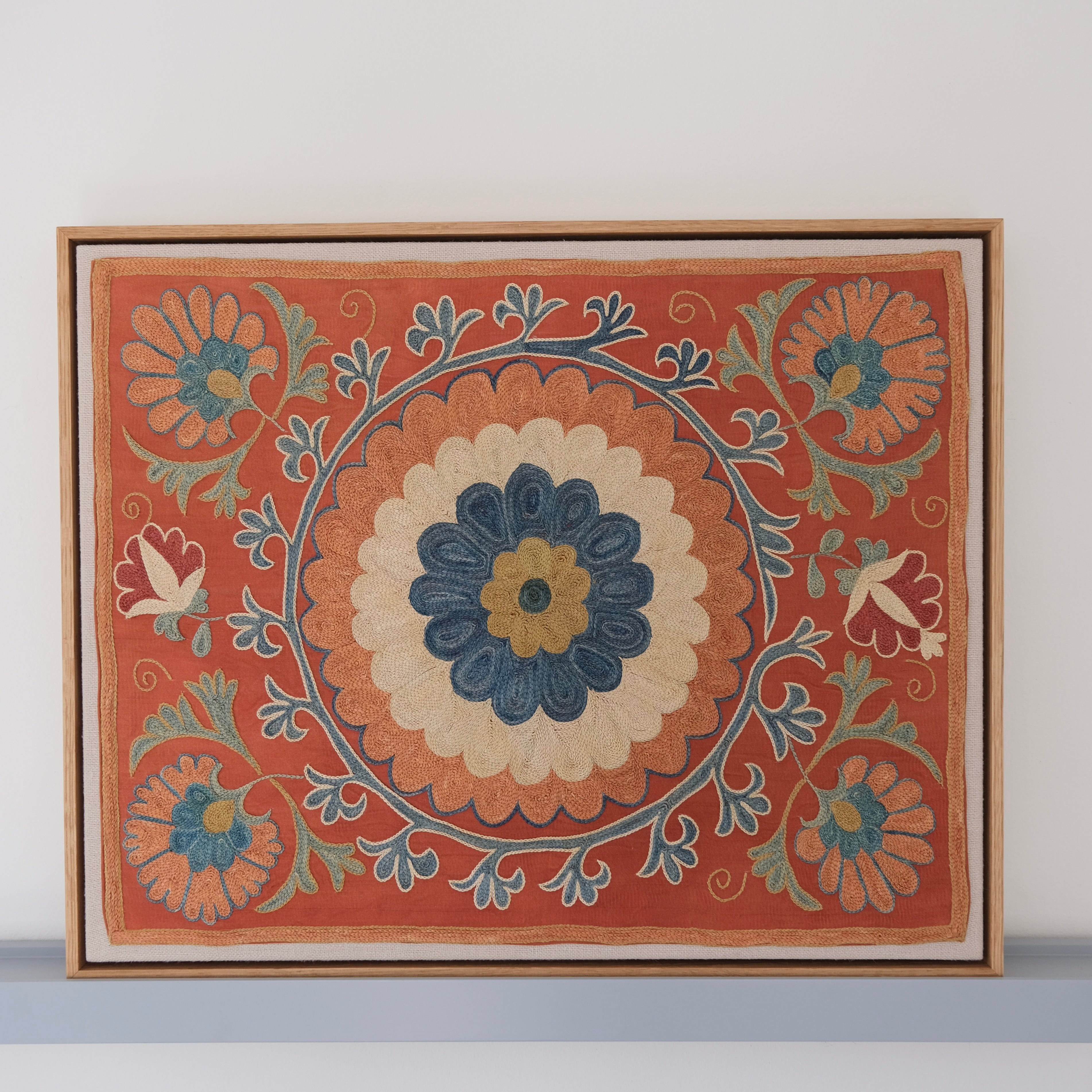 Framed suzani, embroidered textile art, wooden frame, dark orange with blue and green floral motifs