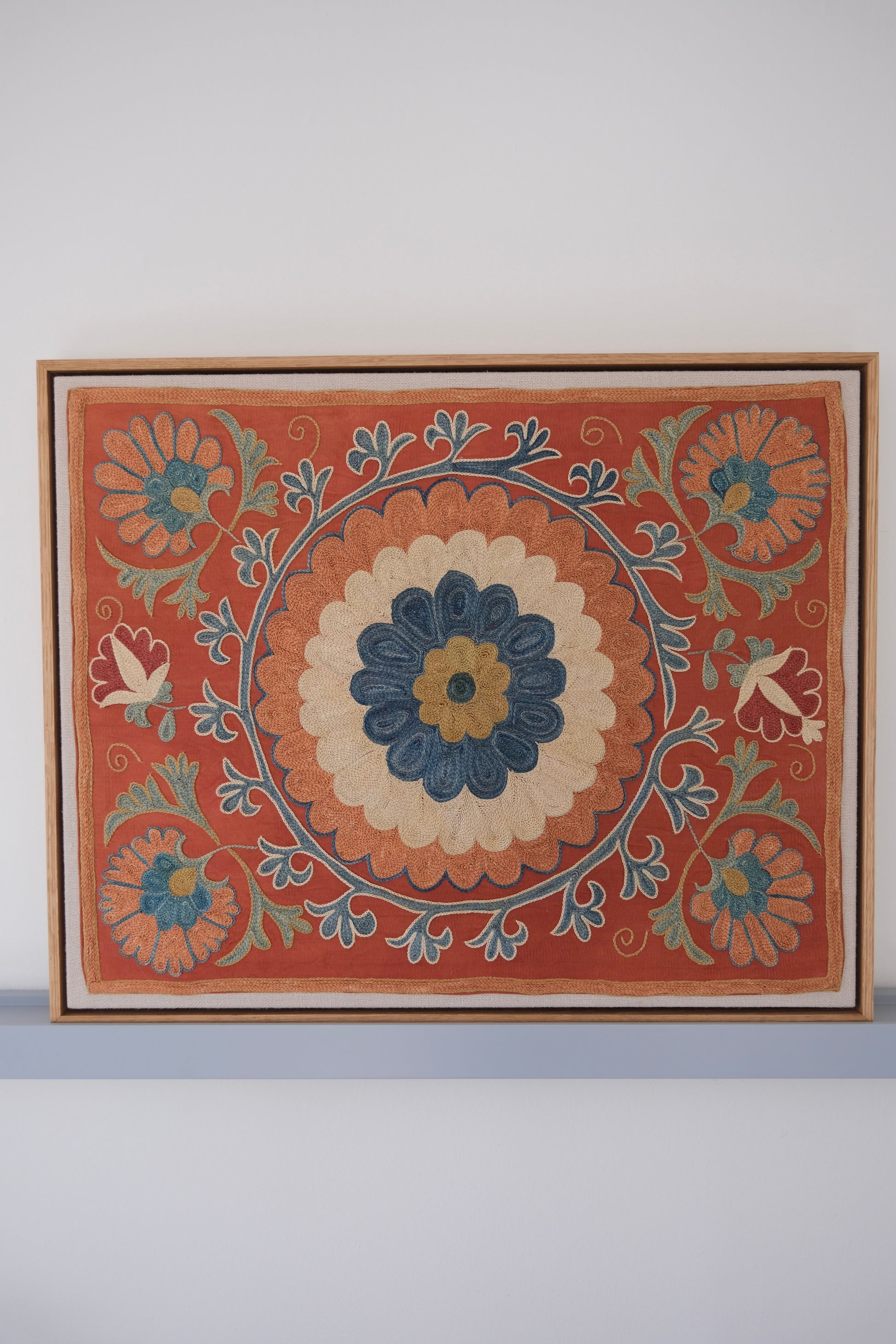 Framed suzani, embroidered textile art, wooden frame, dark orange with blue and green floral motifs